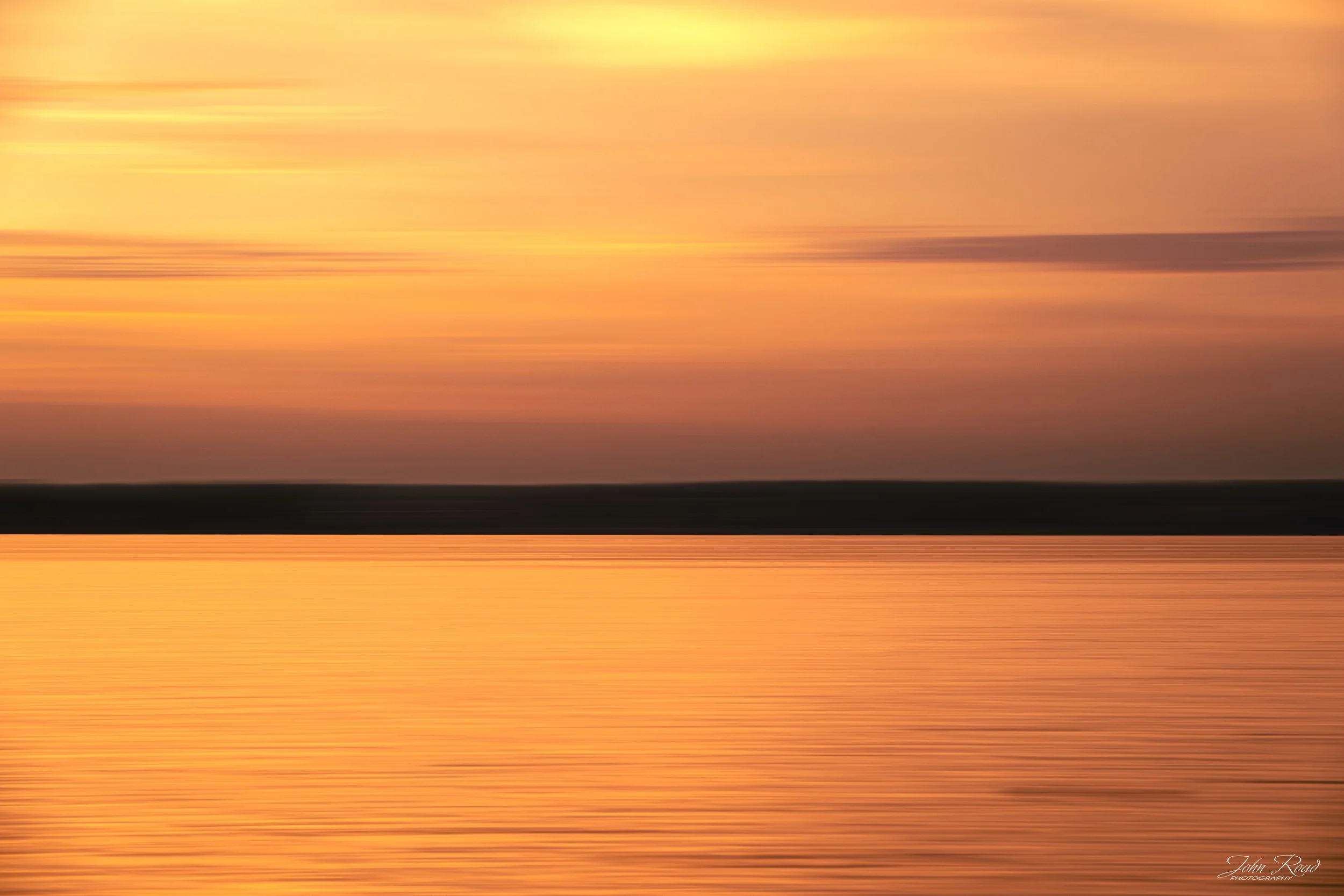 Minimalist sunrise landscape with a calm lake and soft orange sky