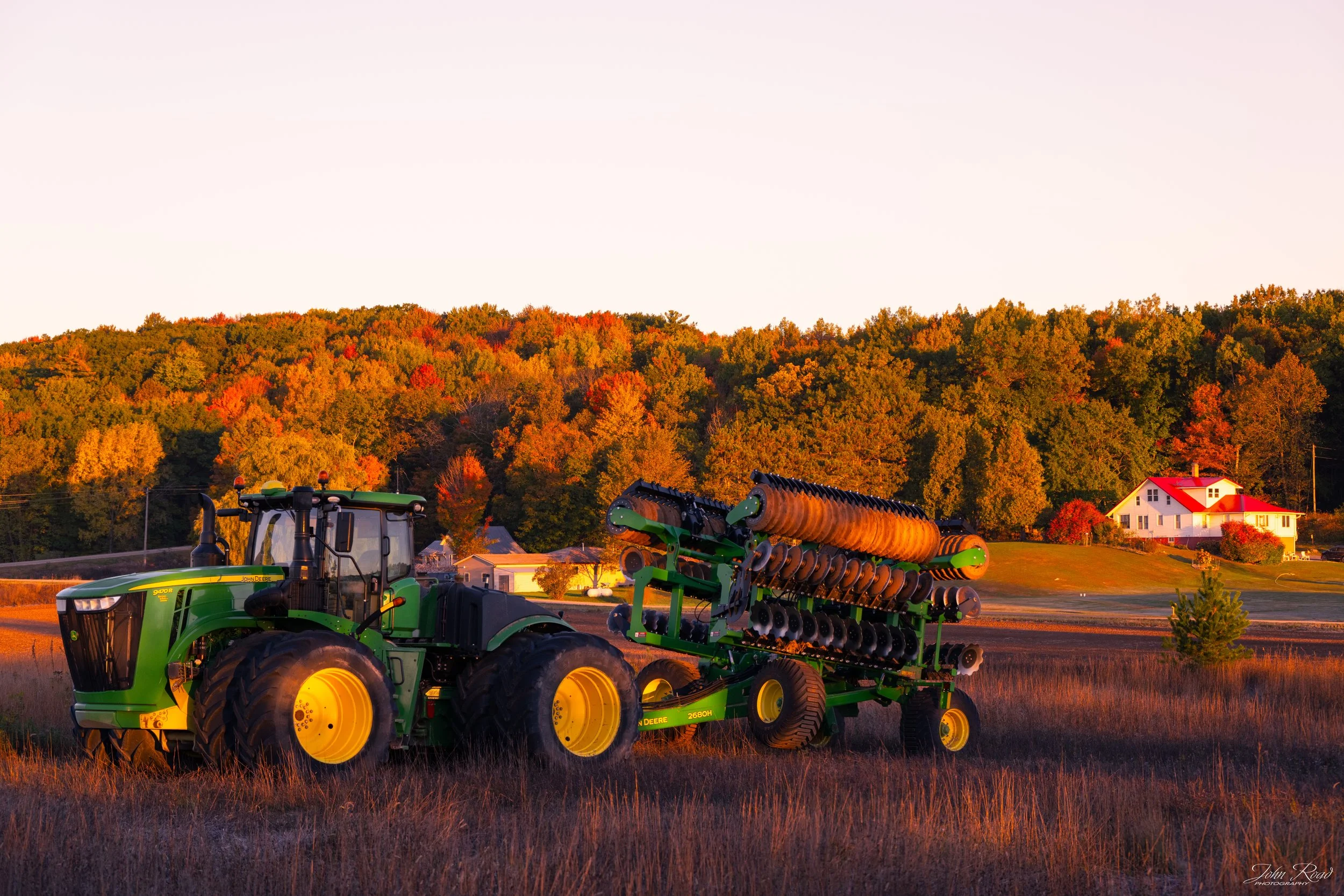 Fine art photograph of a tractor in golden morning light during harvest season, captured by John Road.