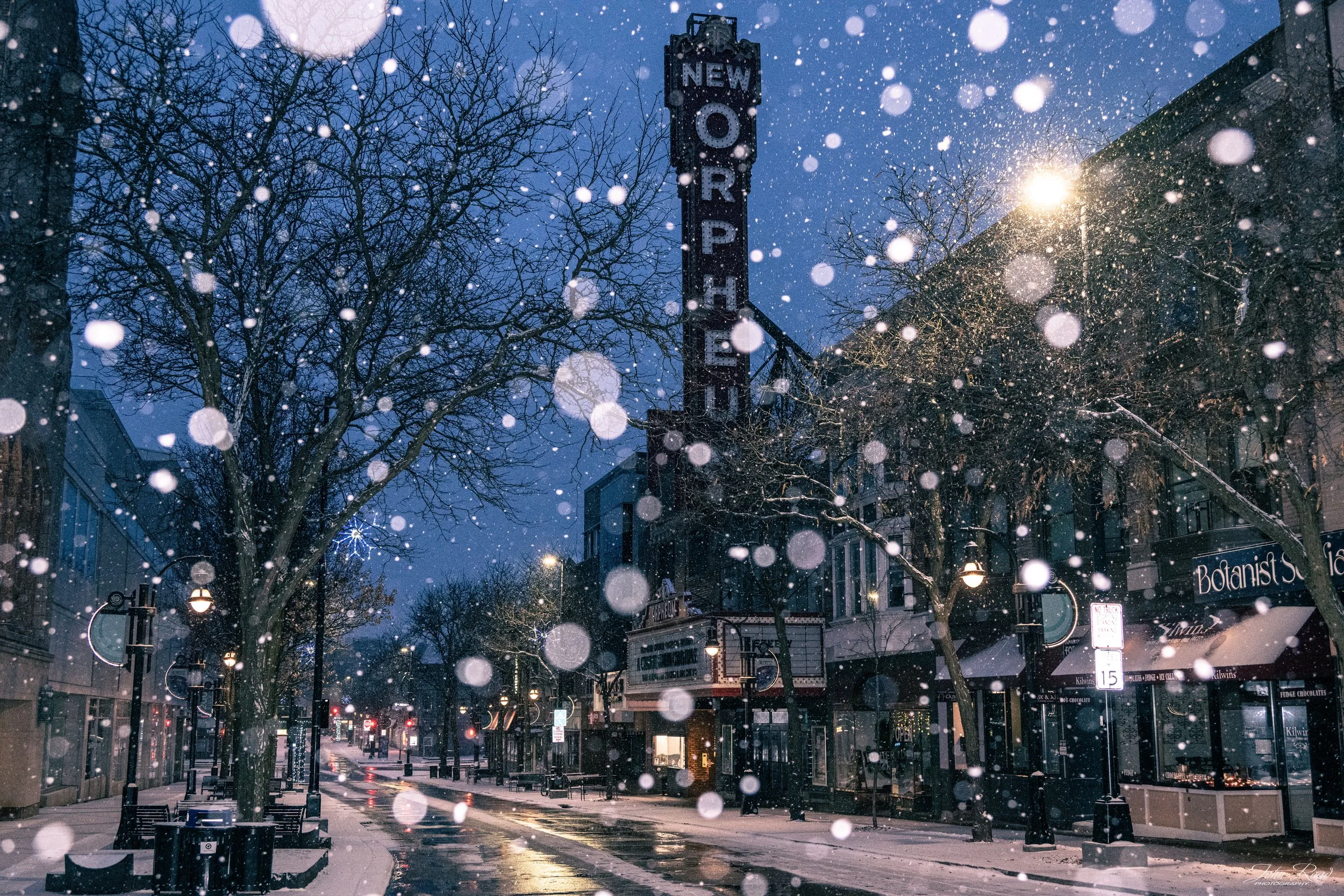 Snow falling around the Orpheum Theatre sign on State Street in Madison, photographed by John Road.