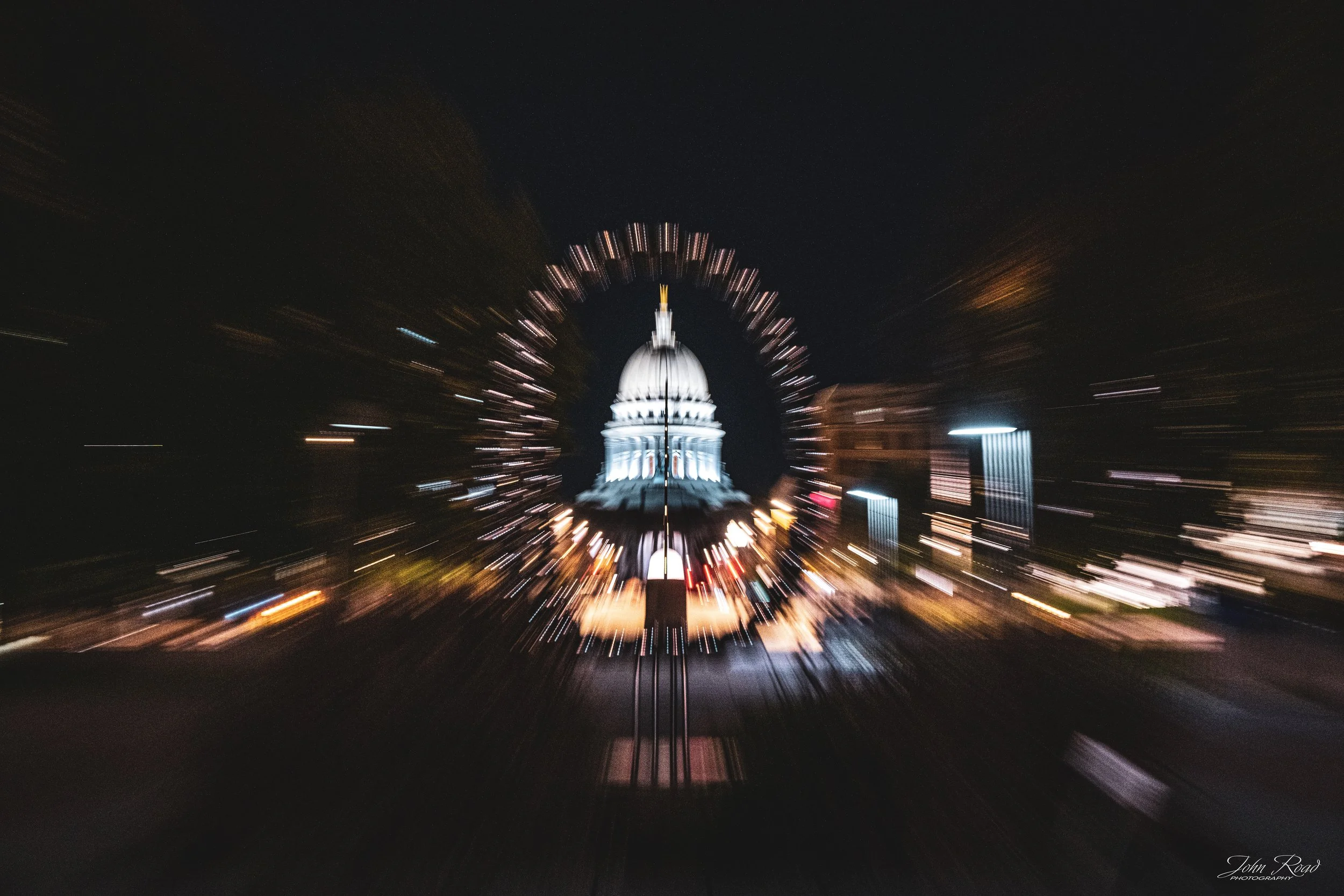 The illuminated dome of the Wisconsin State Capitol surrounded by radial light streaks in an abstract nighttime ICM photograph in Madison.