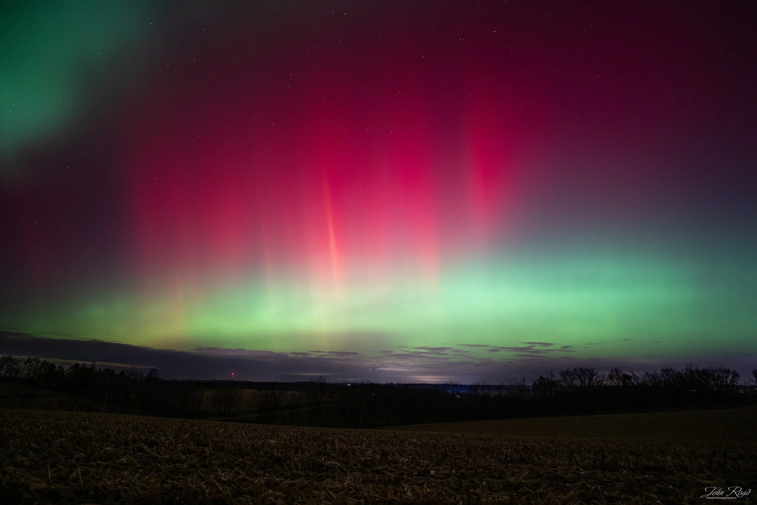 Red and green aurora lights dancing over Wisconsin fields, fine art night landscape photograph by John Road.