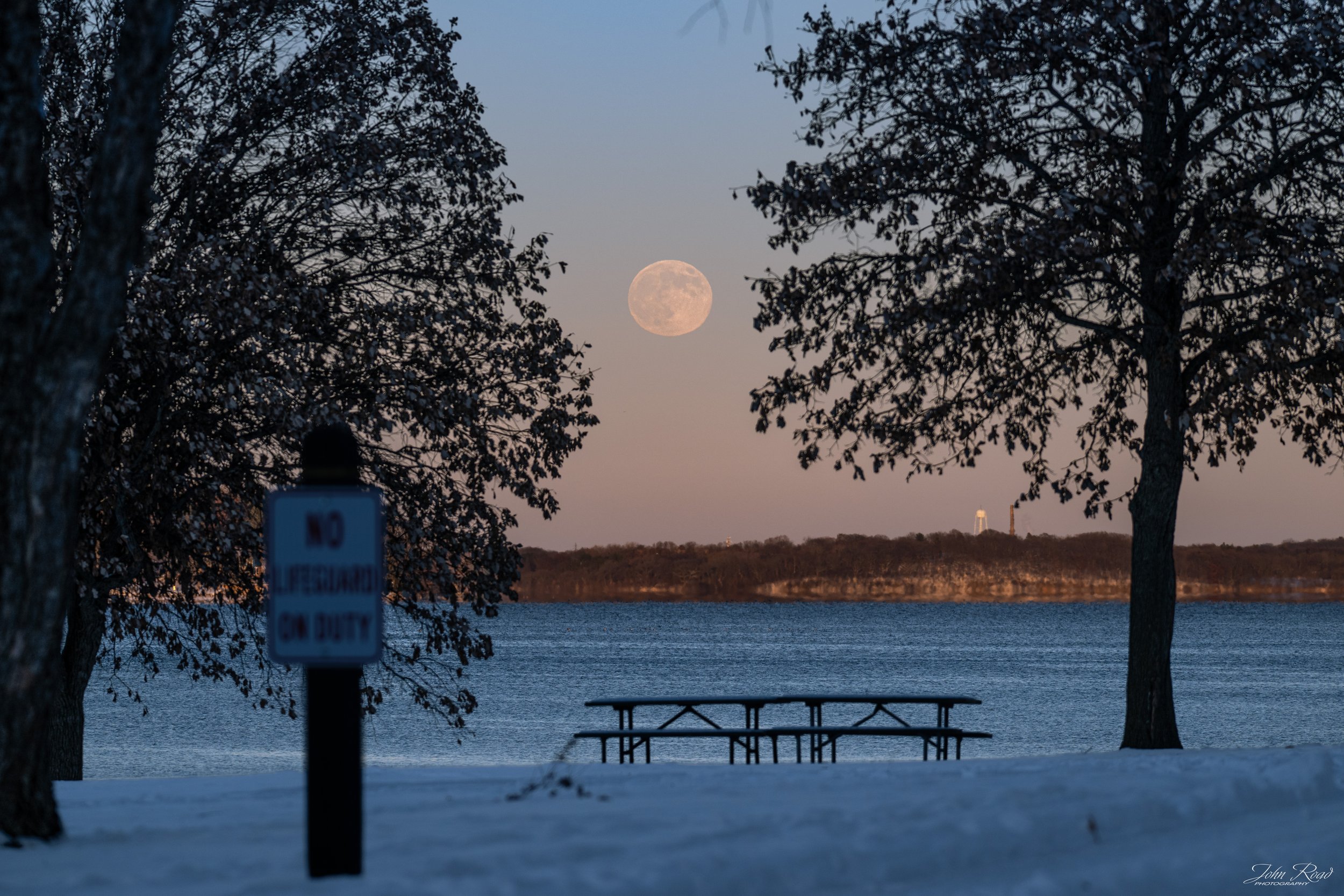 Cold Moon rising over winter landscape in Wisconsin, atmospheric full moon photography by John Road.