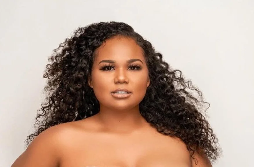 Woman with curly hair against plain background