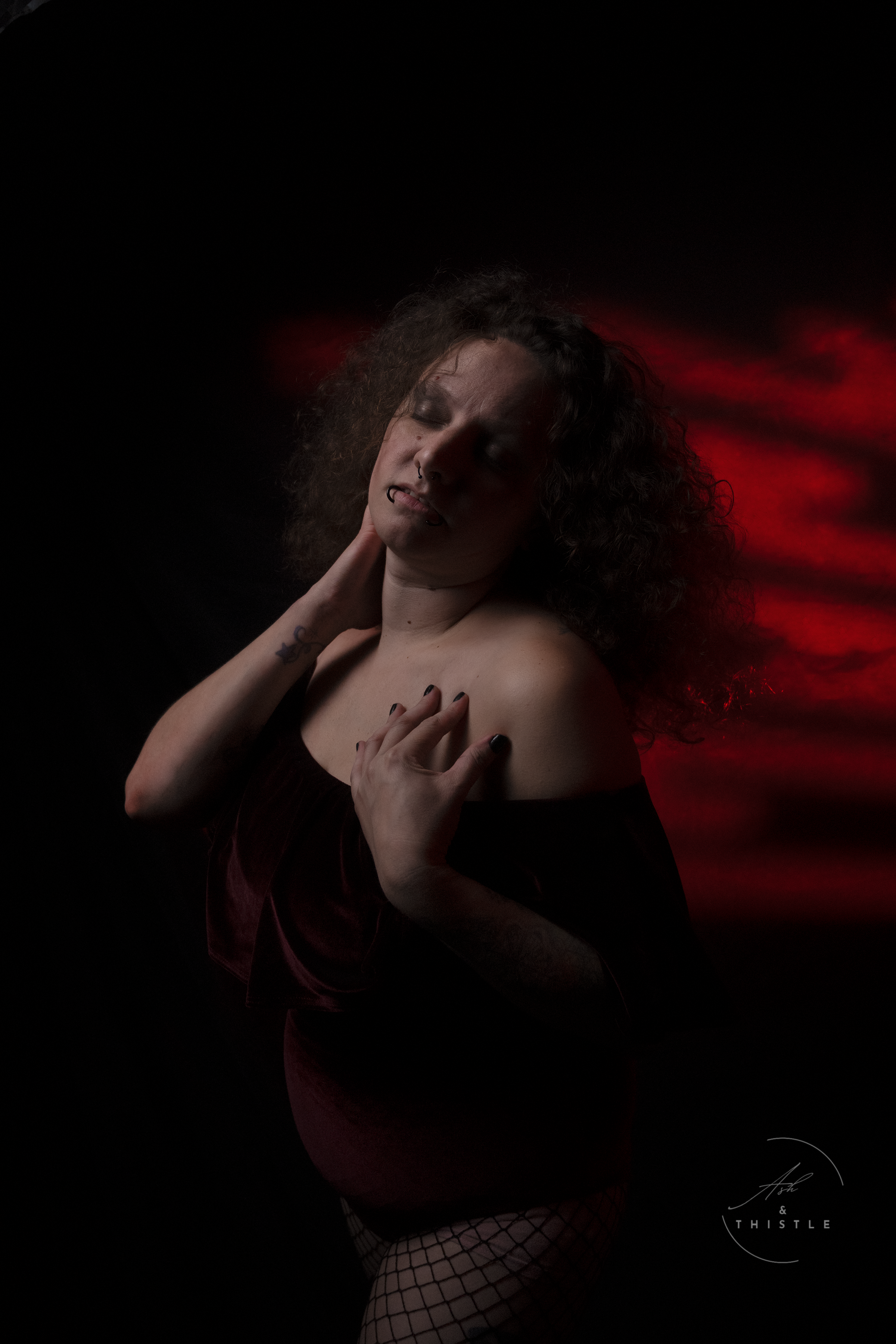 toledo boudoir woman in a moody setting with red lighting