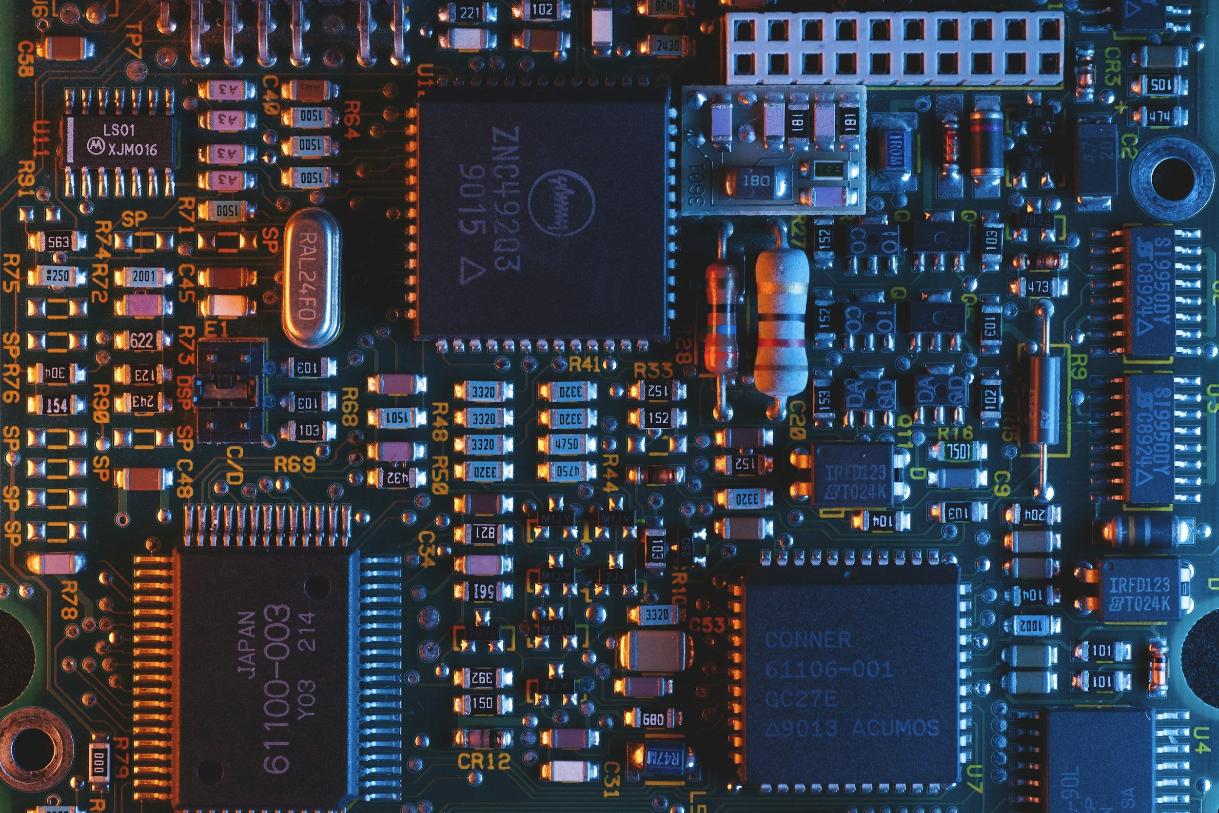 Close-up of a computer circuit board with various electronic components, including chips, resistors, and capacitors.