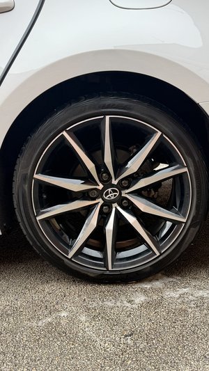Car wheel with alloy rim on a white vehicle.