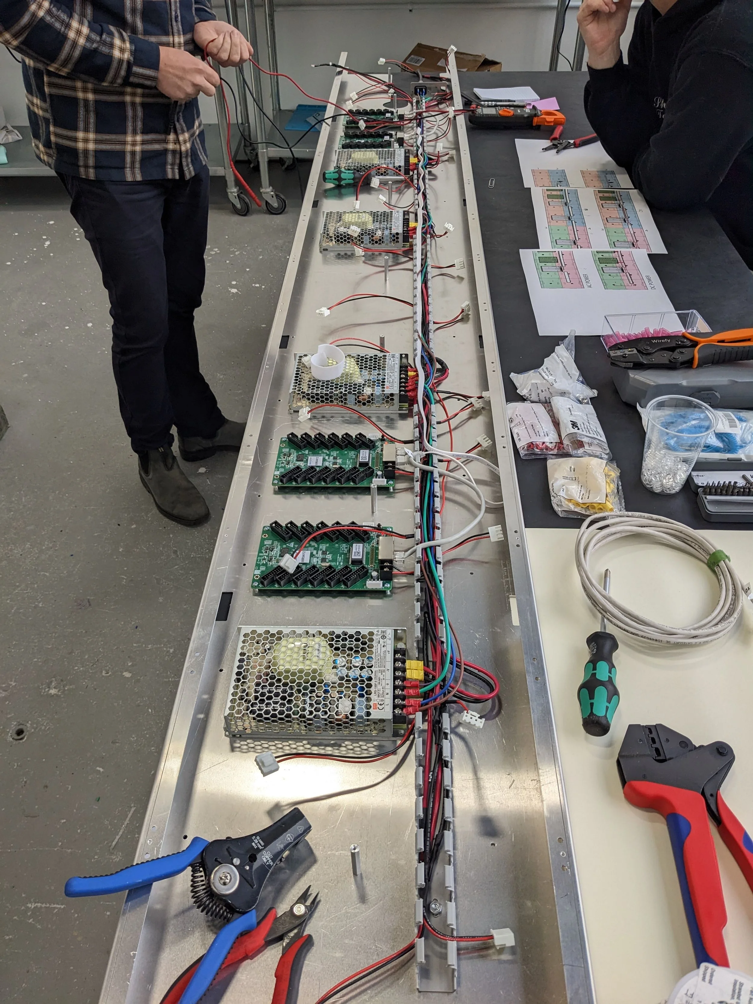 Partial assembly with Power Supplies, Data Receiver Cards (green), Low-Voltage Wiring Harness and Ethernet cables, and plastic Wire Duct