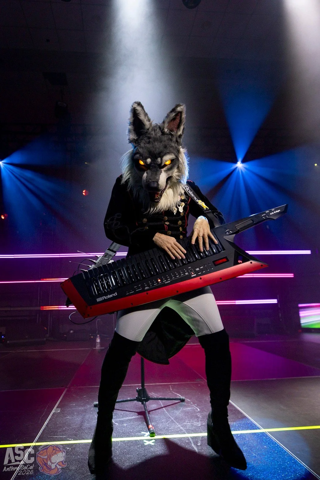ChronoWolf on stage playing his keytar with colorful lighting..