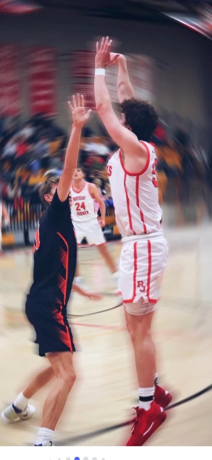 Joseph Haubert rises for a jump shot in a competitive Regis Jesuit High School basketball matchup, highlighting shooting form and offensive skill.
