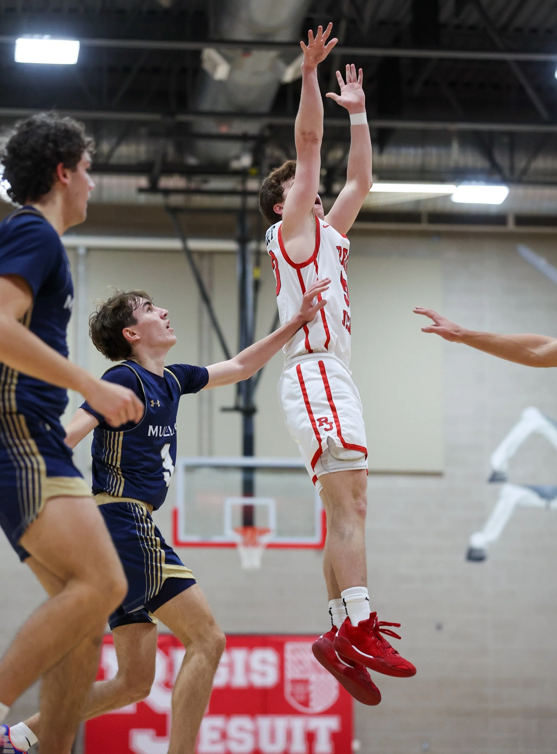 High-energy moment of Joseph Haubert pushing the fast break for Regis Jesuit basketball, emphasizing speed, transition play, and playmaking.