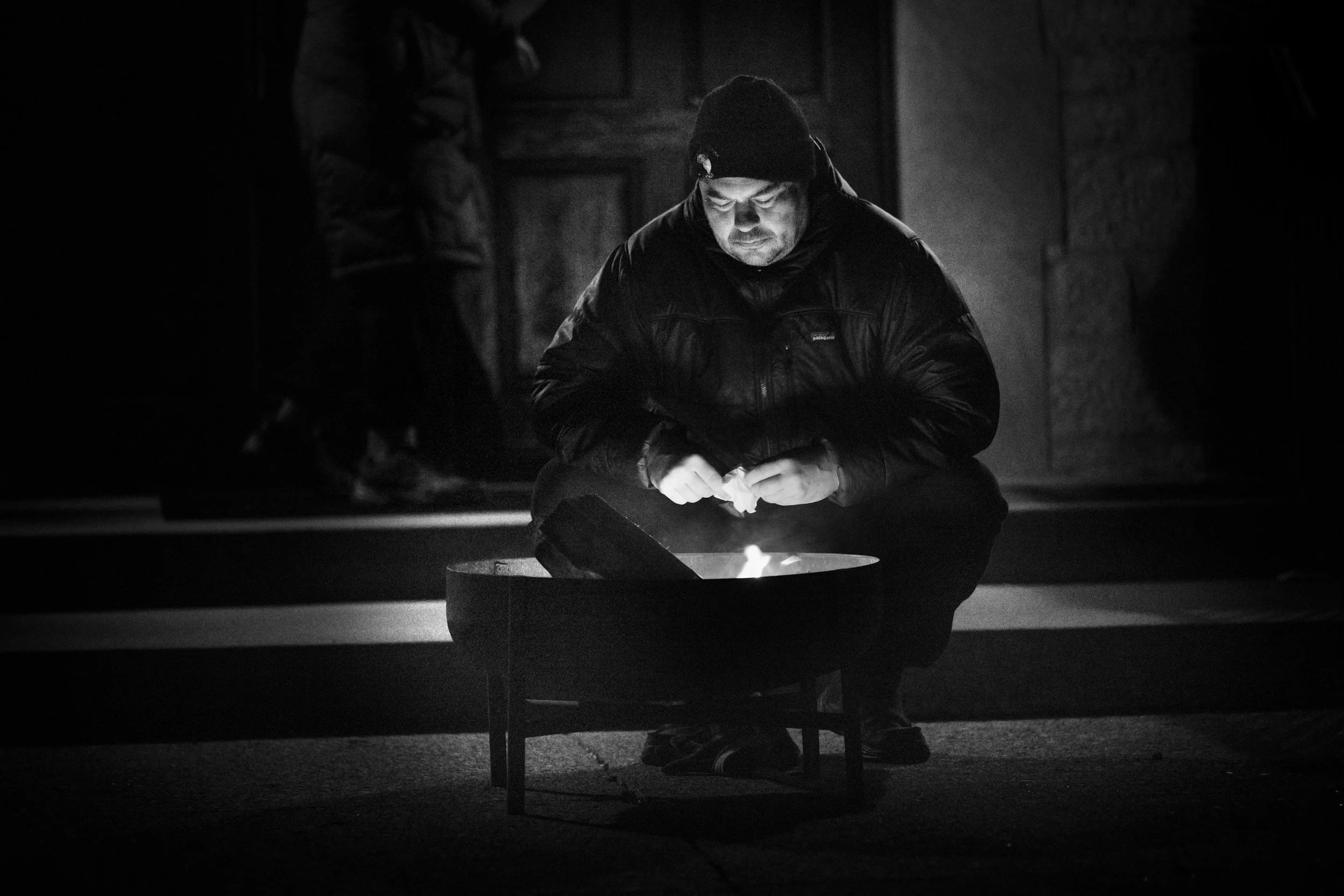 Andy Frick starts a small bonfire at the base of the steps of the church. Temperatures hovered around 40 degrees, and the light winds felt like 32 degrees.