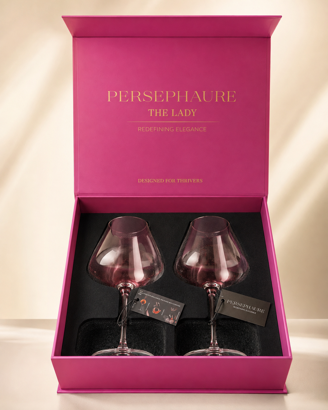 Two pink handblown Lady wine glasses in an open pink Persephaure gift box.