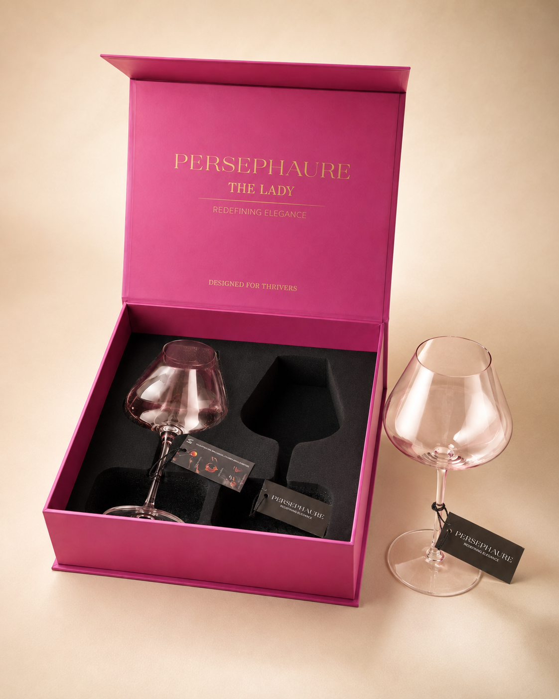 The Lady pink handblown wine glass beside its open Persephaure presentation box.