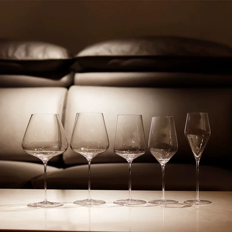 A selection of clear wine and champagne glasses arranged on a softly lit table.