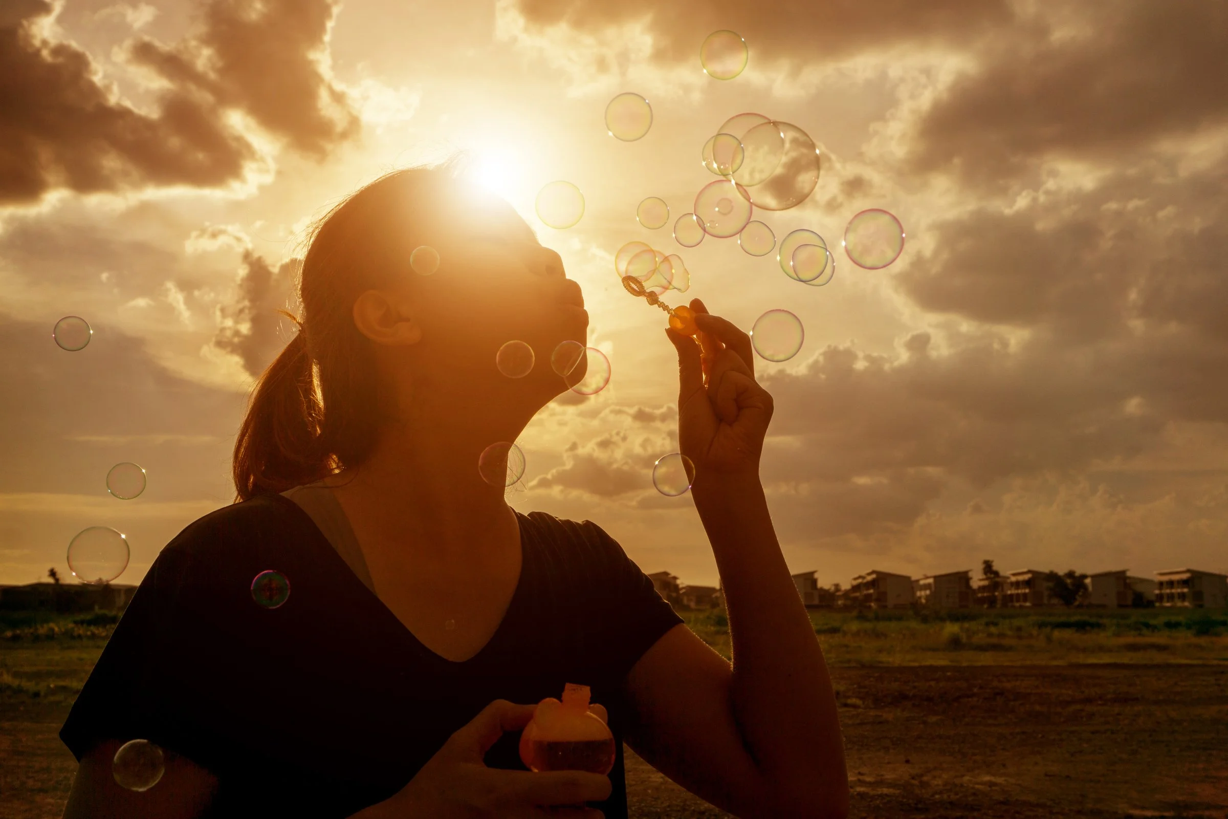A woman blowing bubbles at sunset, symbolizing the release of stress, finding peace, and embracing healing. The image accompanies the message: "Start Your Journey Toward Healing with The Shock Connection Counseling", inviting you to rediscover your s
