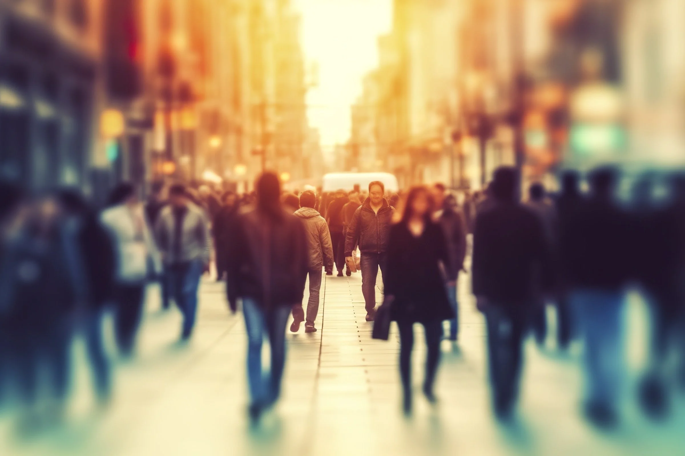 Blurred image of a crowd of people walking on a busy city street, symbolizing the feeling of being lost or disconnected in the midst of change, representing the journey of rediscovering oneself after divorce.