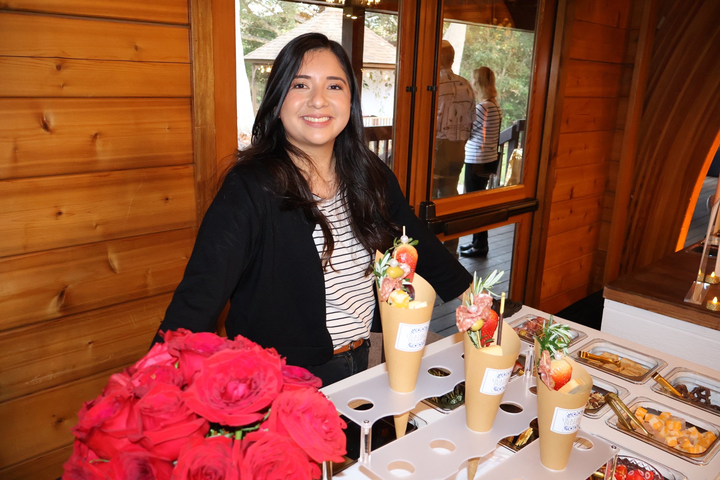 Laurie’s customers, Mariana and Carmen holding hands on a green lawn on their wedding day.
