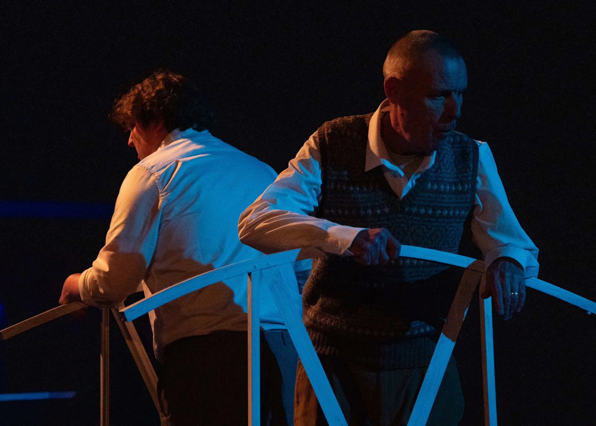 Drama scene: Nightime. Two men on a bridge, looking out  in opposite directions.