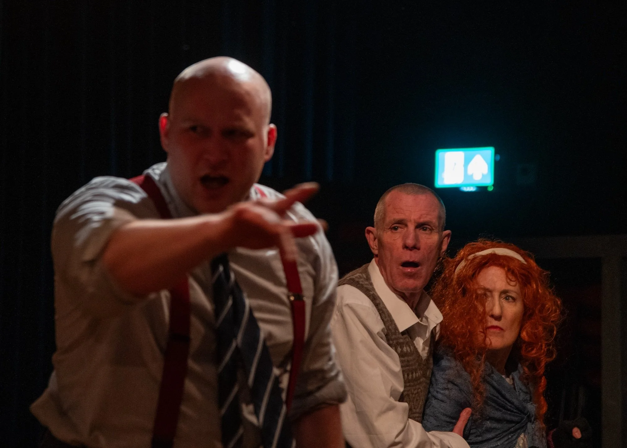 Drama scene: A threatening near figure, with an apprehensive couple looking nervously on.