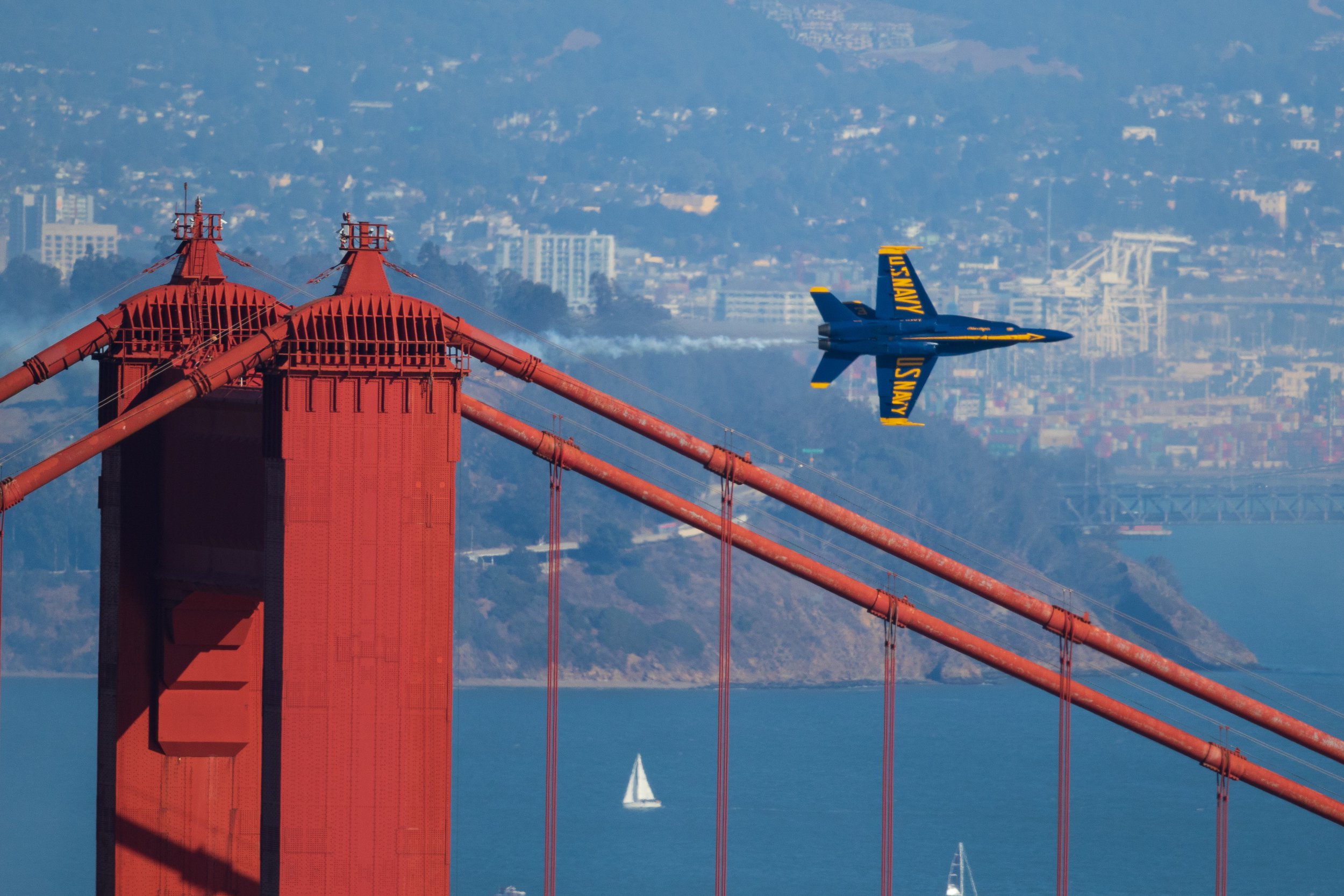 A Blue Angel turns-and-burns past the north tower of the Golden Gate Bridge.