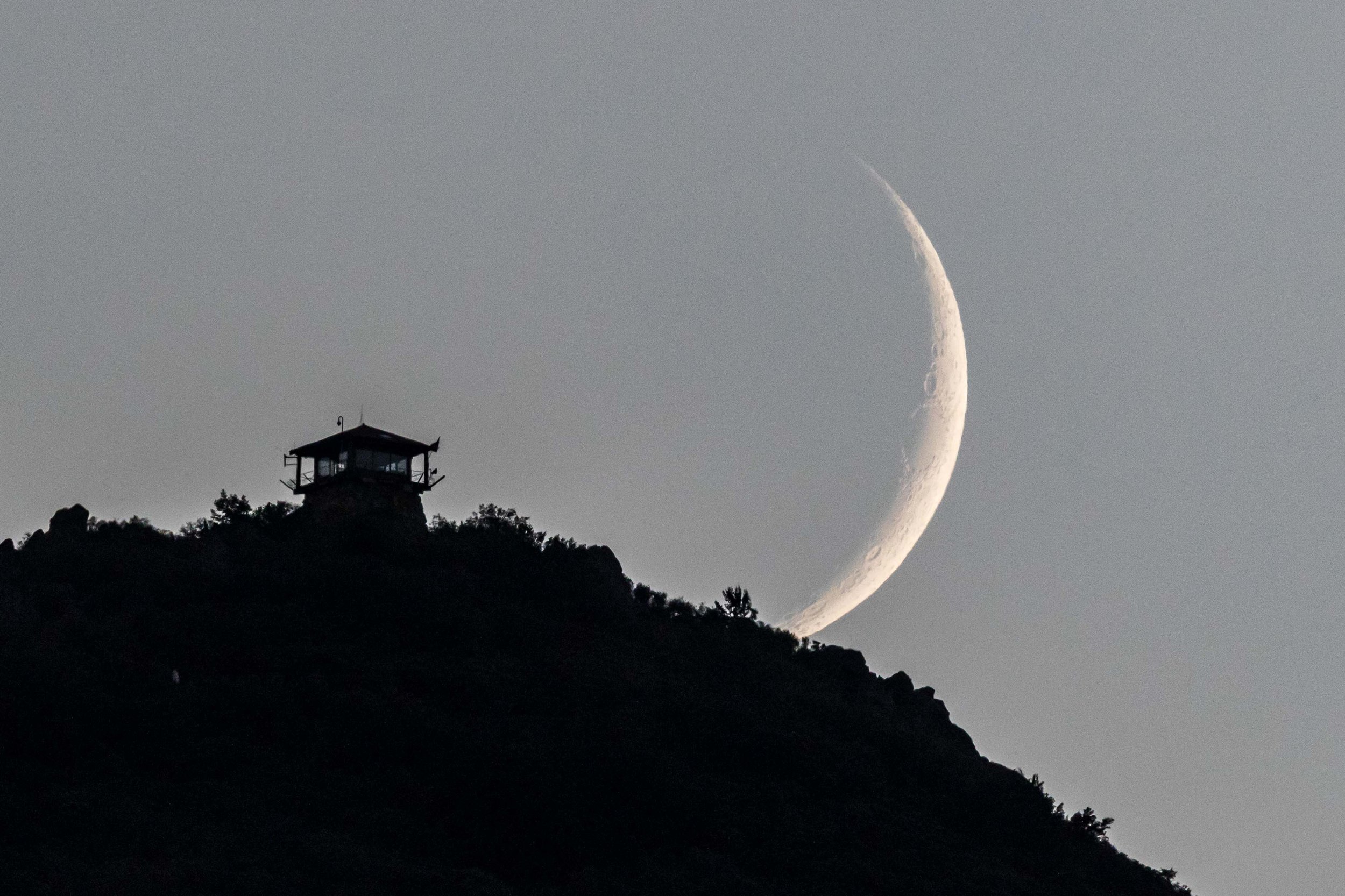The moon sets behind the fire lookout on Mount Tamalpais.