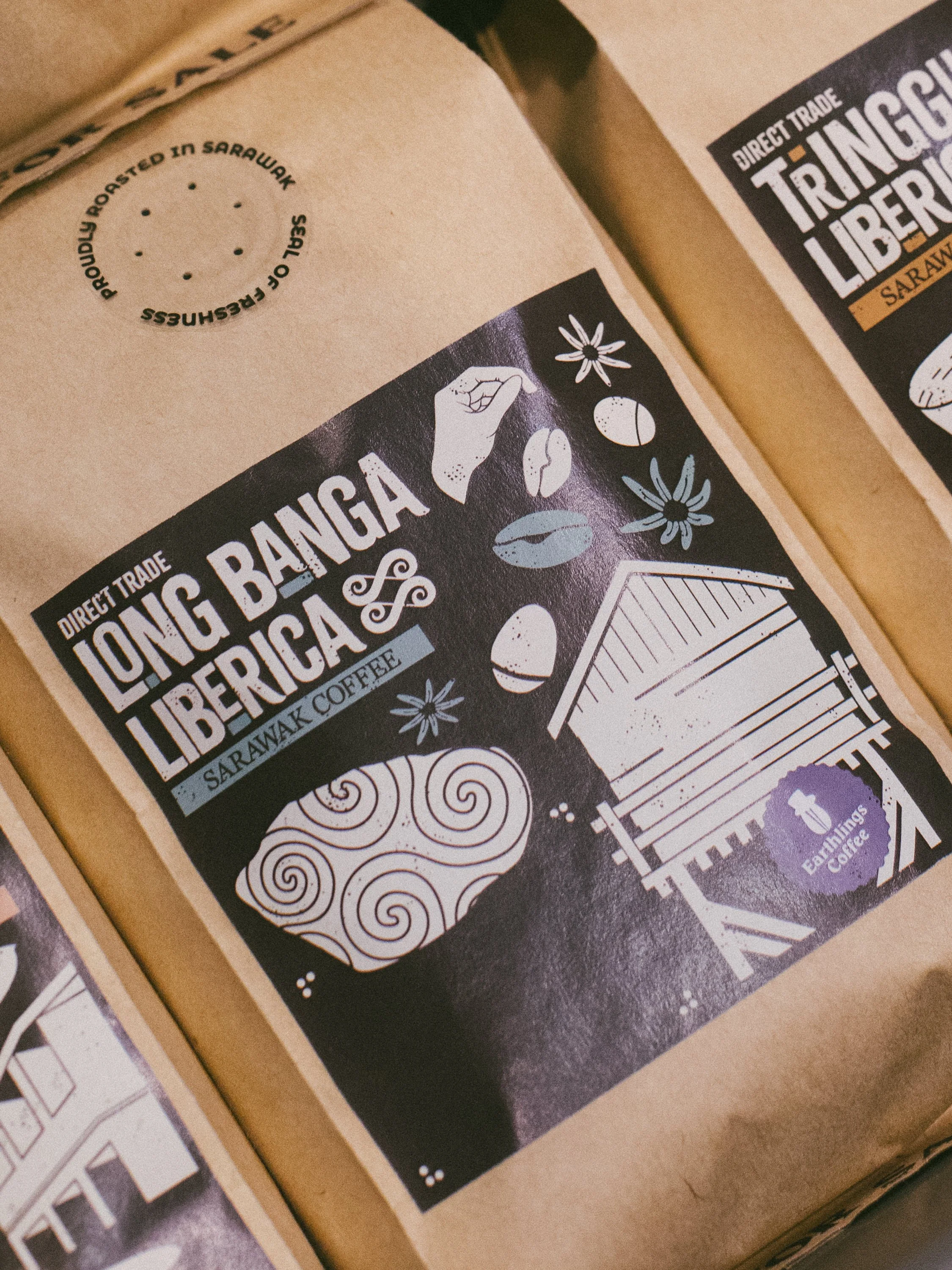 Packaging label for Long Bangga Liberia Sarawak coffee featuring illustrations of coffee beans, a hand, flowers, a wooden structure, and the Sun, with text indicating direct trade, Sarawak, and Earthlings Coffee.