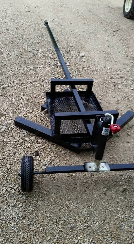 Close-up of a black metal tow bar with a wheel on gravel road
