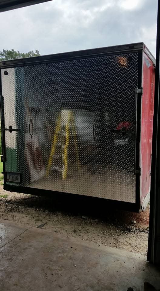 Enclosed trailer with diamond plate exterior in a garage