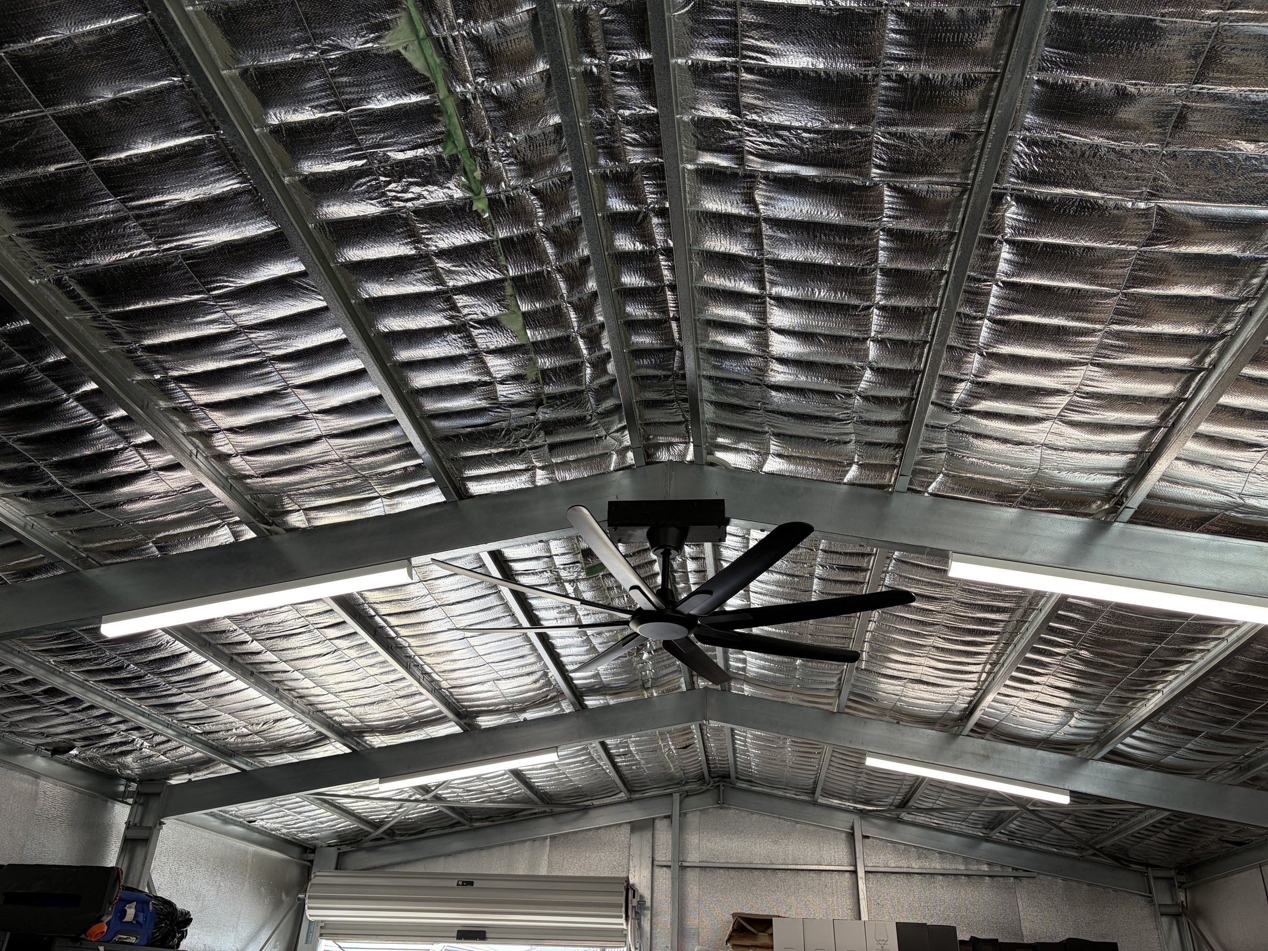 Large black Industrial fan in lined shed