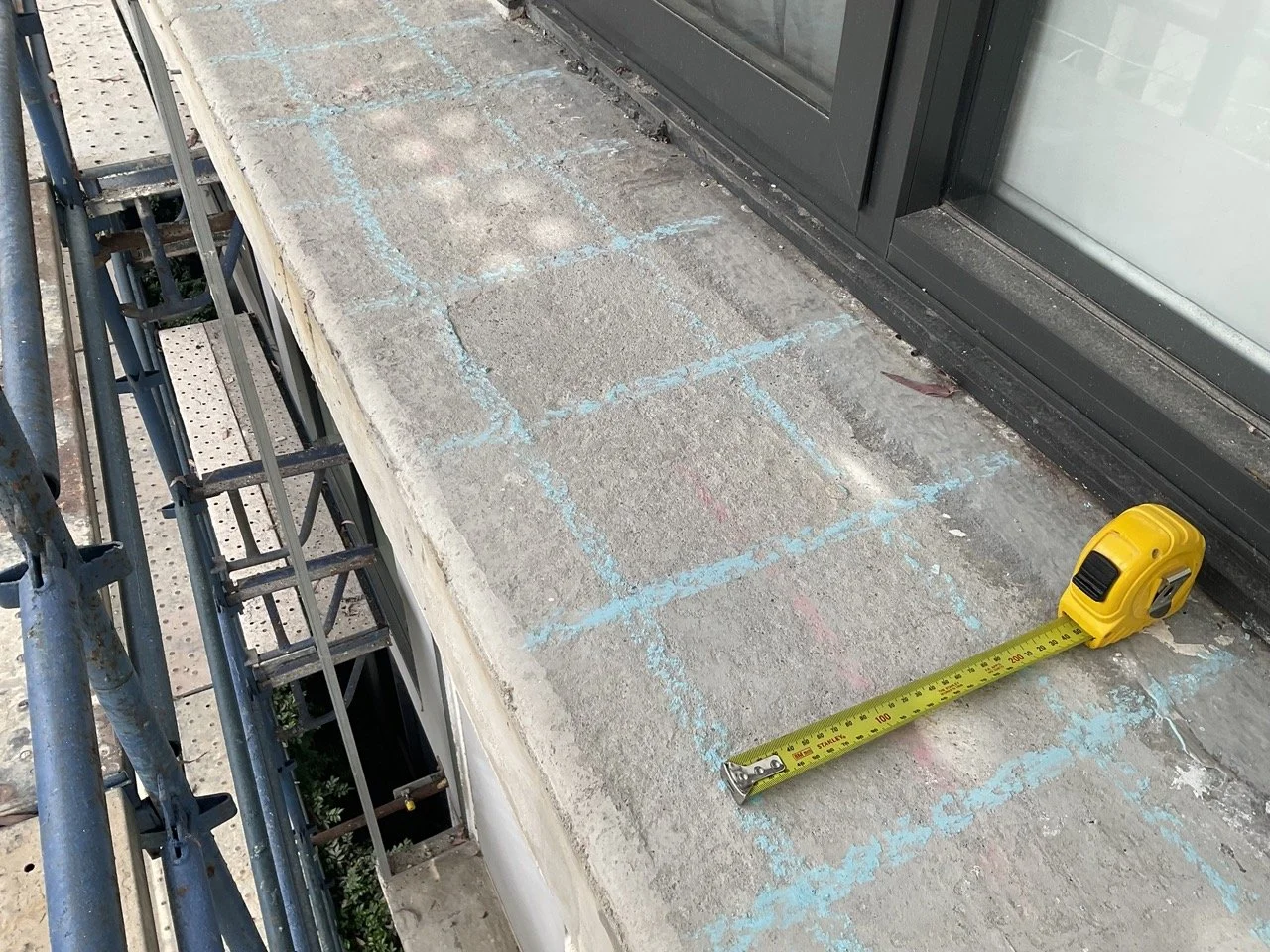 Chalk-marked concrete slab with tape measure