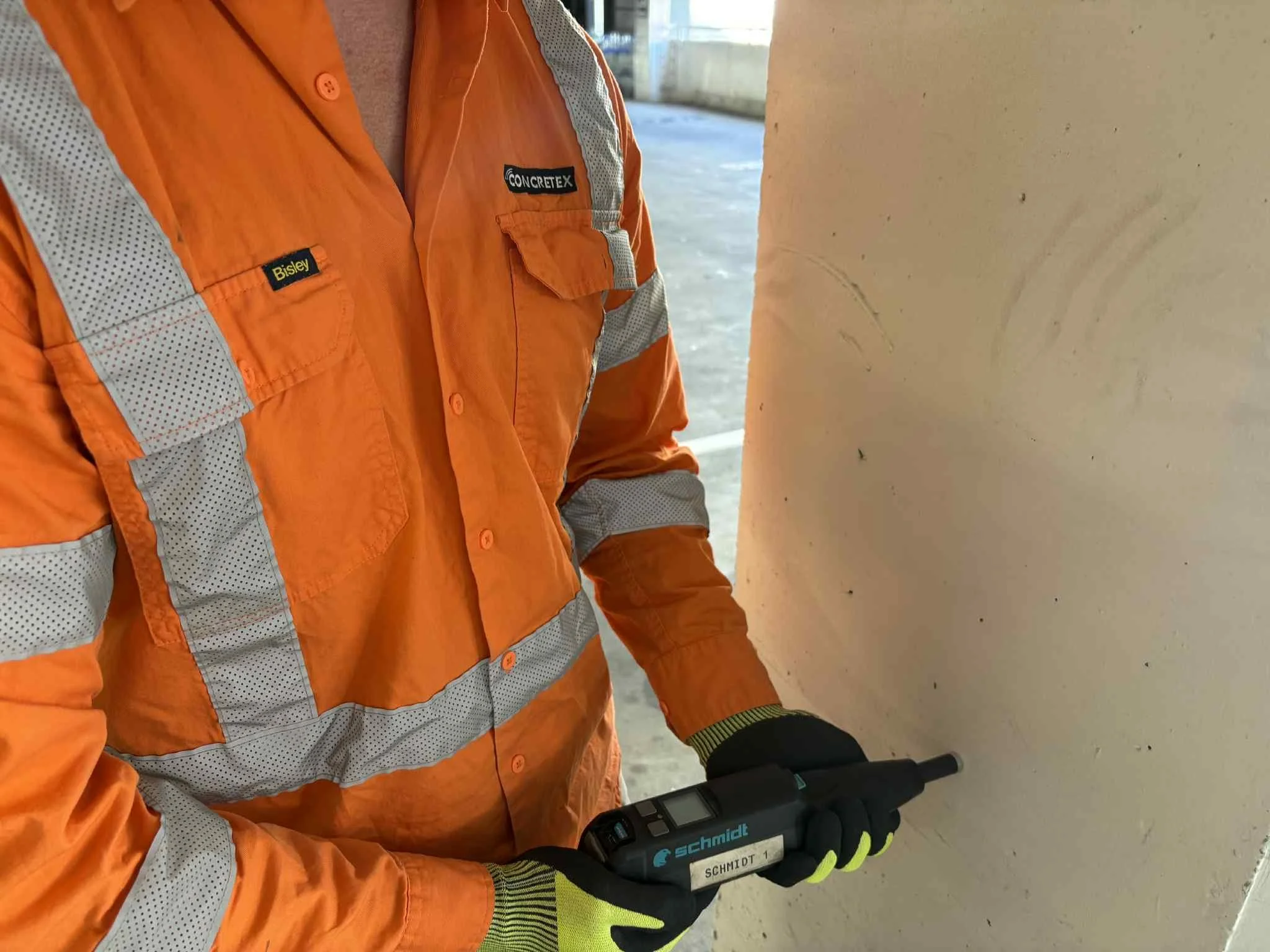 ConcreteX technician using Schmidt Hammer on concrete column