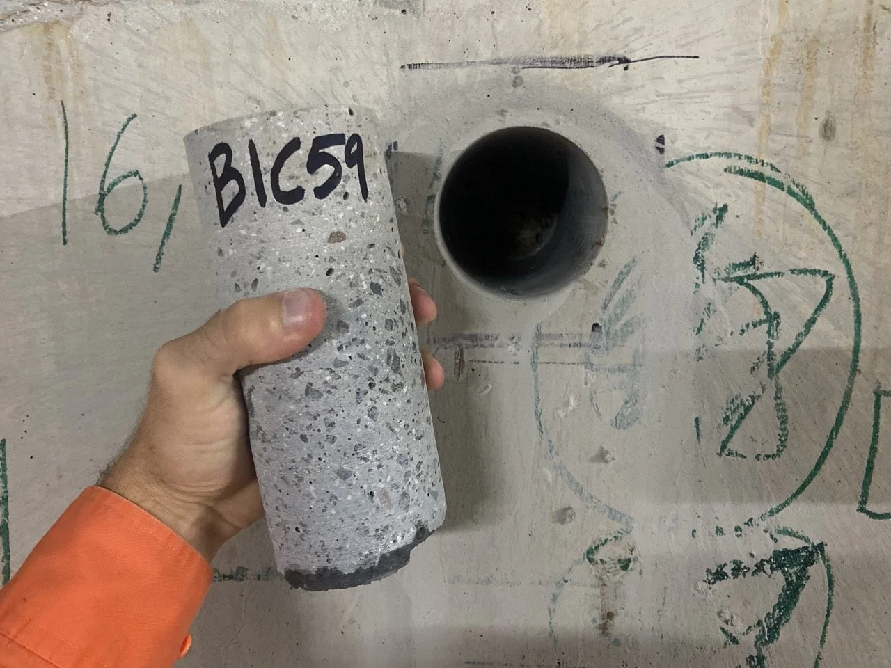 Technician holding labelled concrete core sample