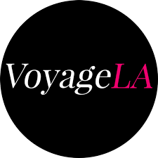 VoyageLA logo with white and pink text on a black circular background.