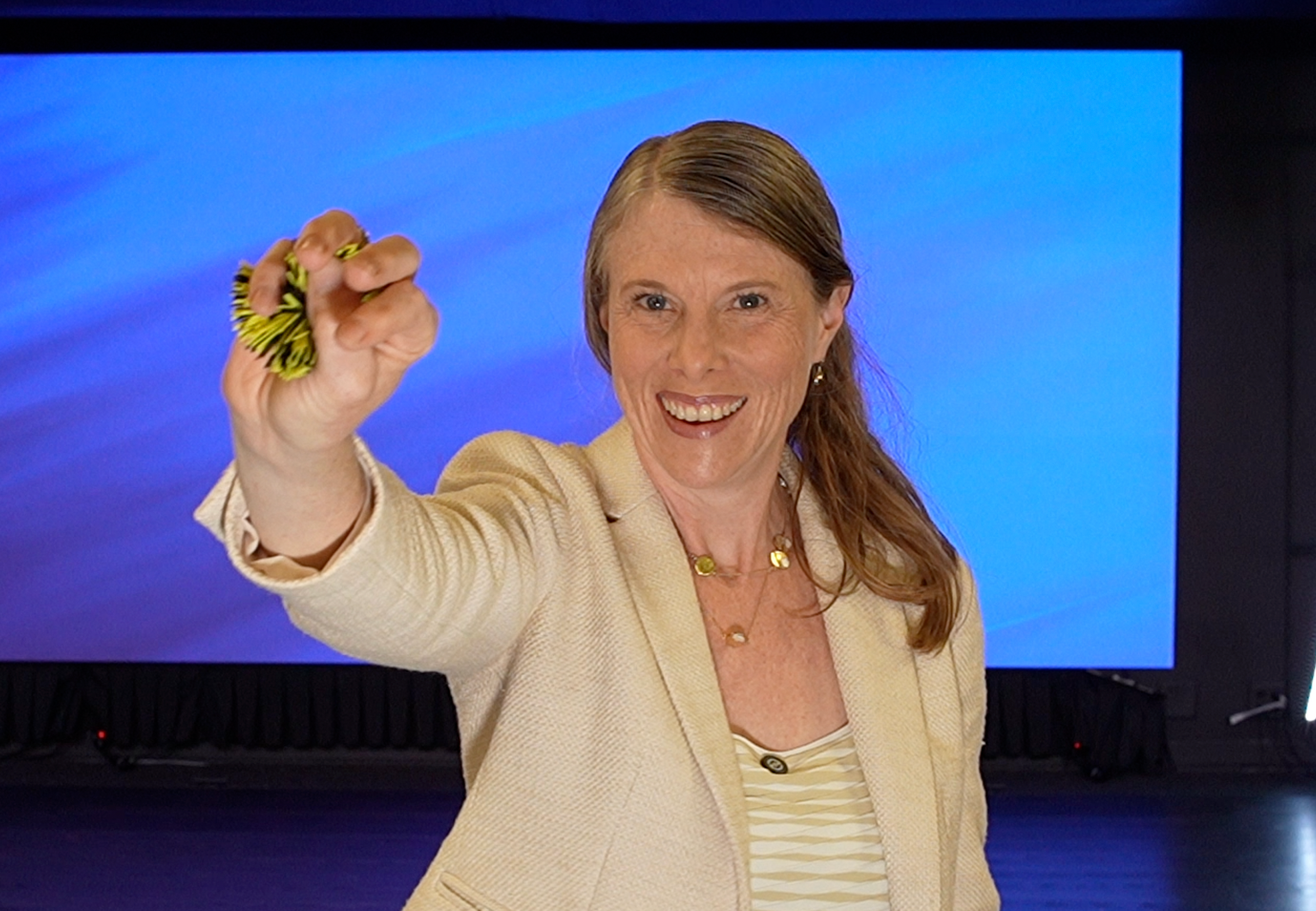 A woman standing and holding a Koosh ball.