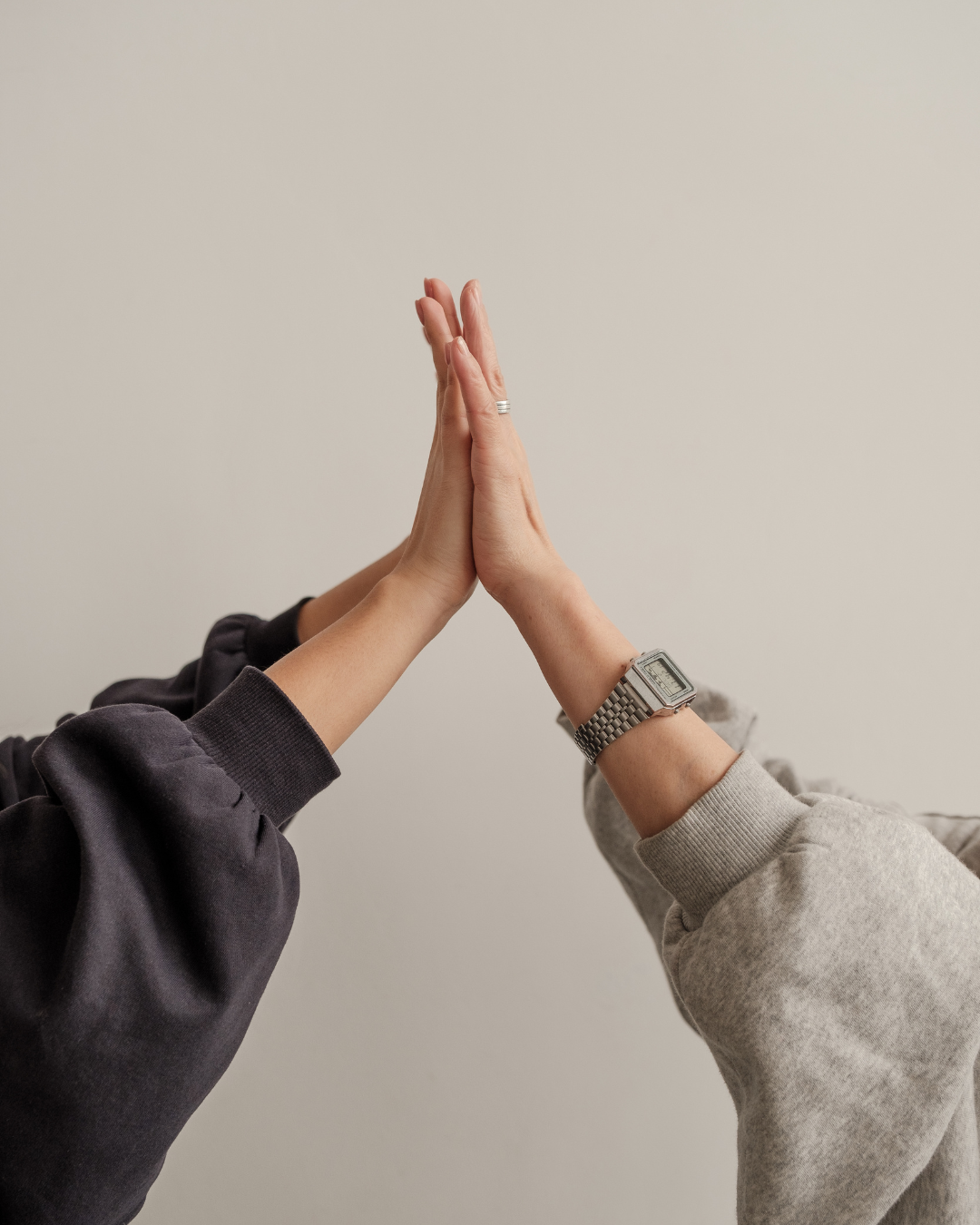 Two people sharing a high five, representing connection and support.