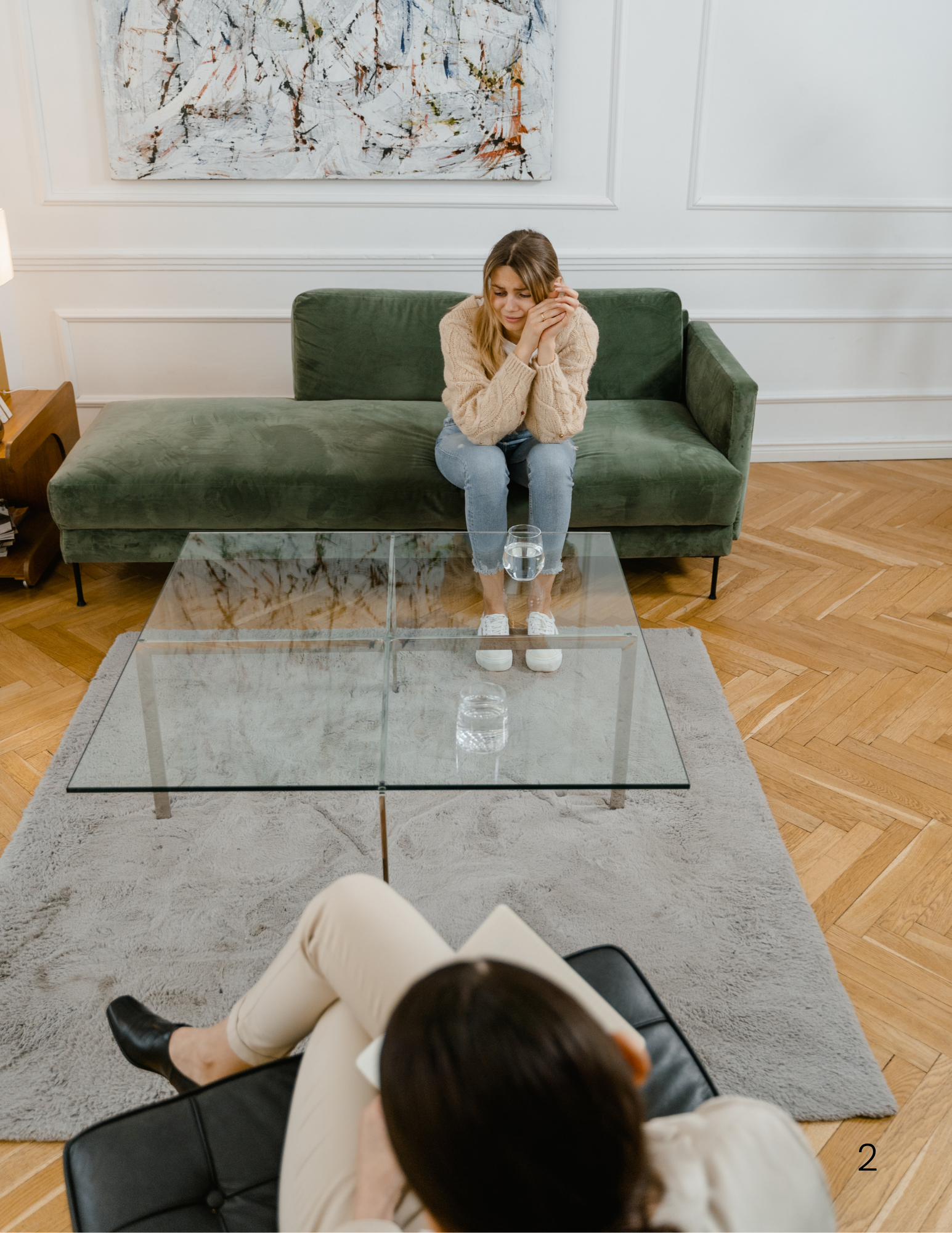 Therapy session in a bright office with a green sofa and abstract artwork.