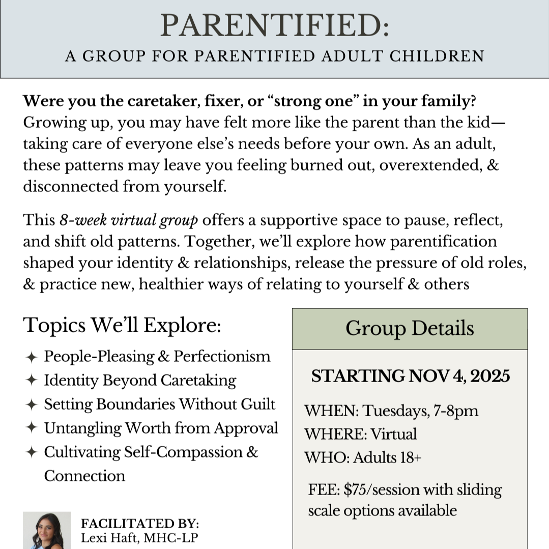 Two women sitting across from each other in a conversation, with a small table and flower vase between them in a bright, elegant room.