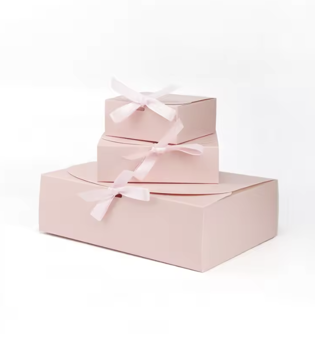 Stacked pink gift boxes with bows on a white background.