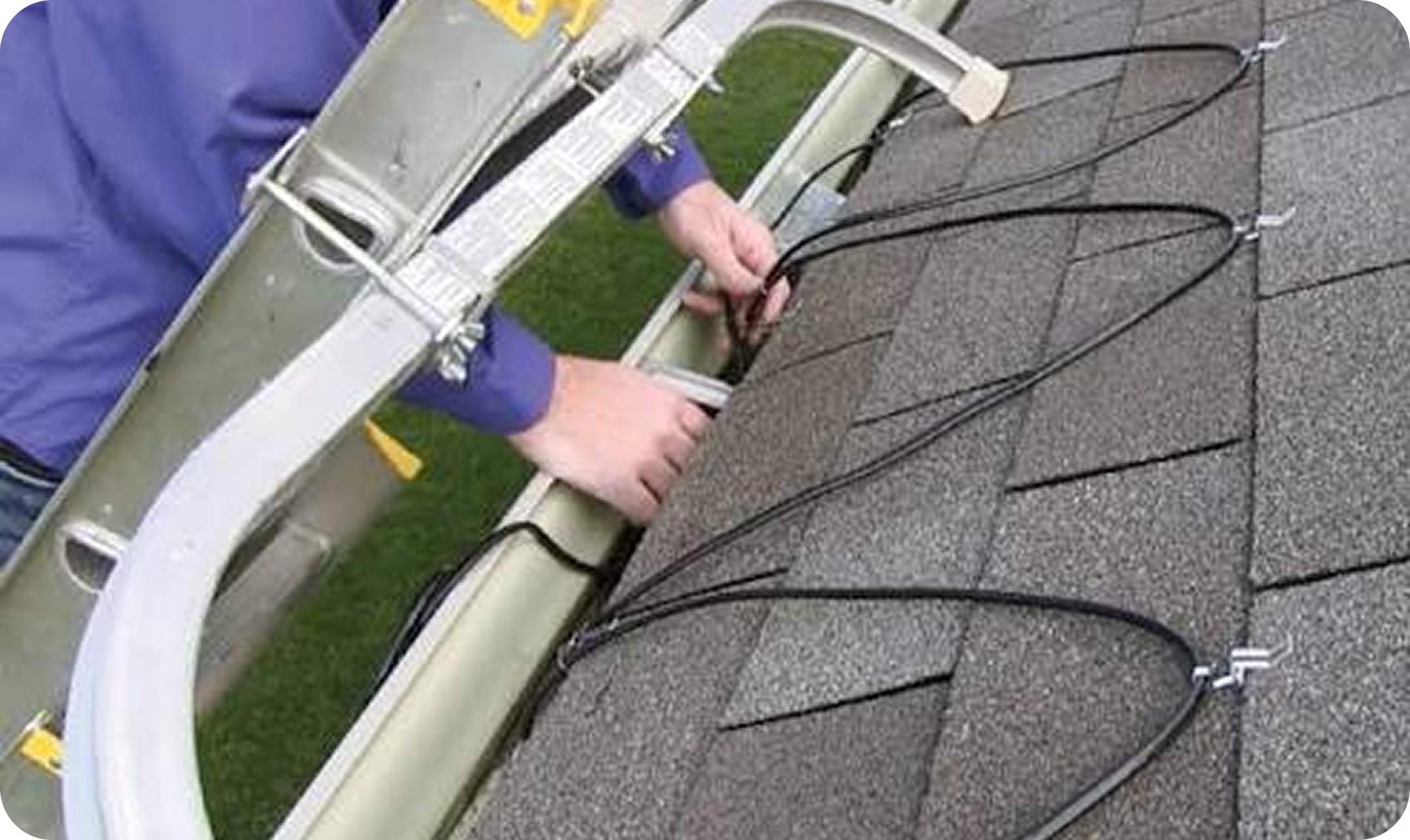 Person working on electrical wiring on the side of a house roof.