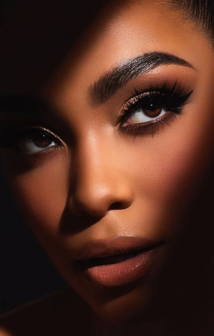 Close-up of a woman's face with dramatic makeup, featuring bold eyeliner and well-defined eyebrows.