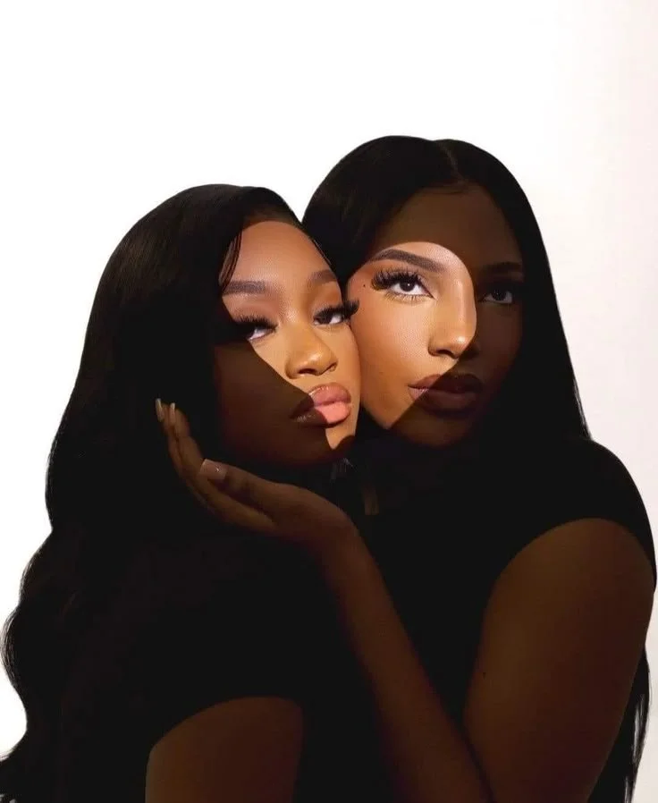 Two women with overlapping facial projections creating a creative shadow effect on their faces.