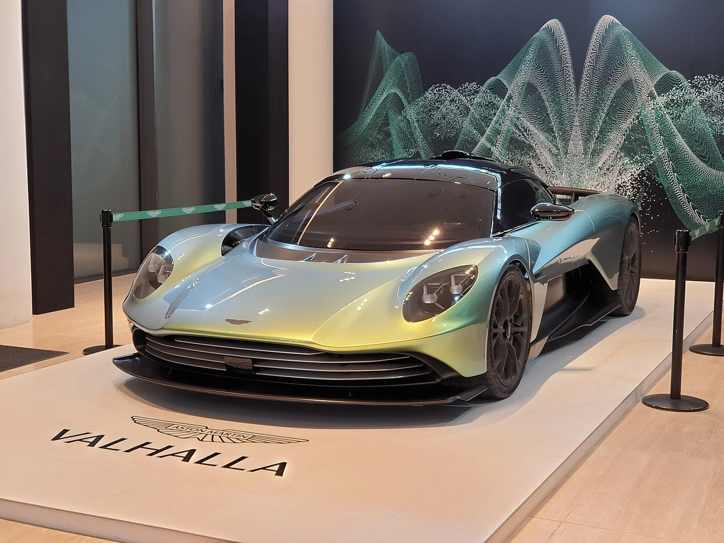 Aston Martin Valhalla Hybrid-Hypercar in silberner Lackierung auf offener Straße, seitliche Perspektive, Fokus auf Aerodynamik und Design