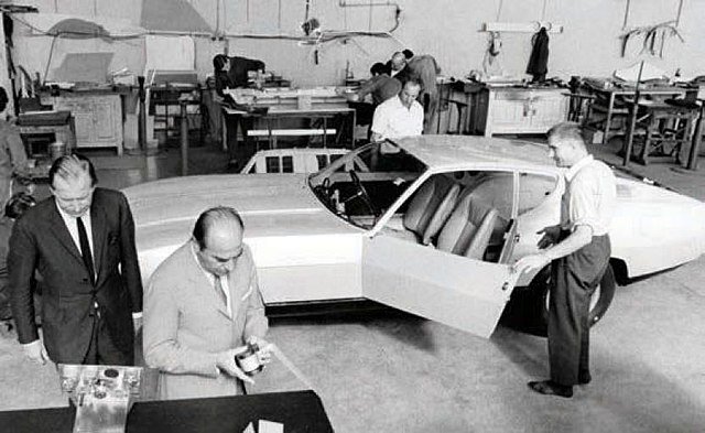 Designers and engineers working on the 1967 Bertone Jaguar Pirana prototype inside the workshop, showcasing early Italian design and craftsmanship.