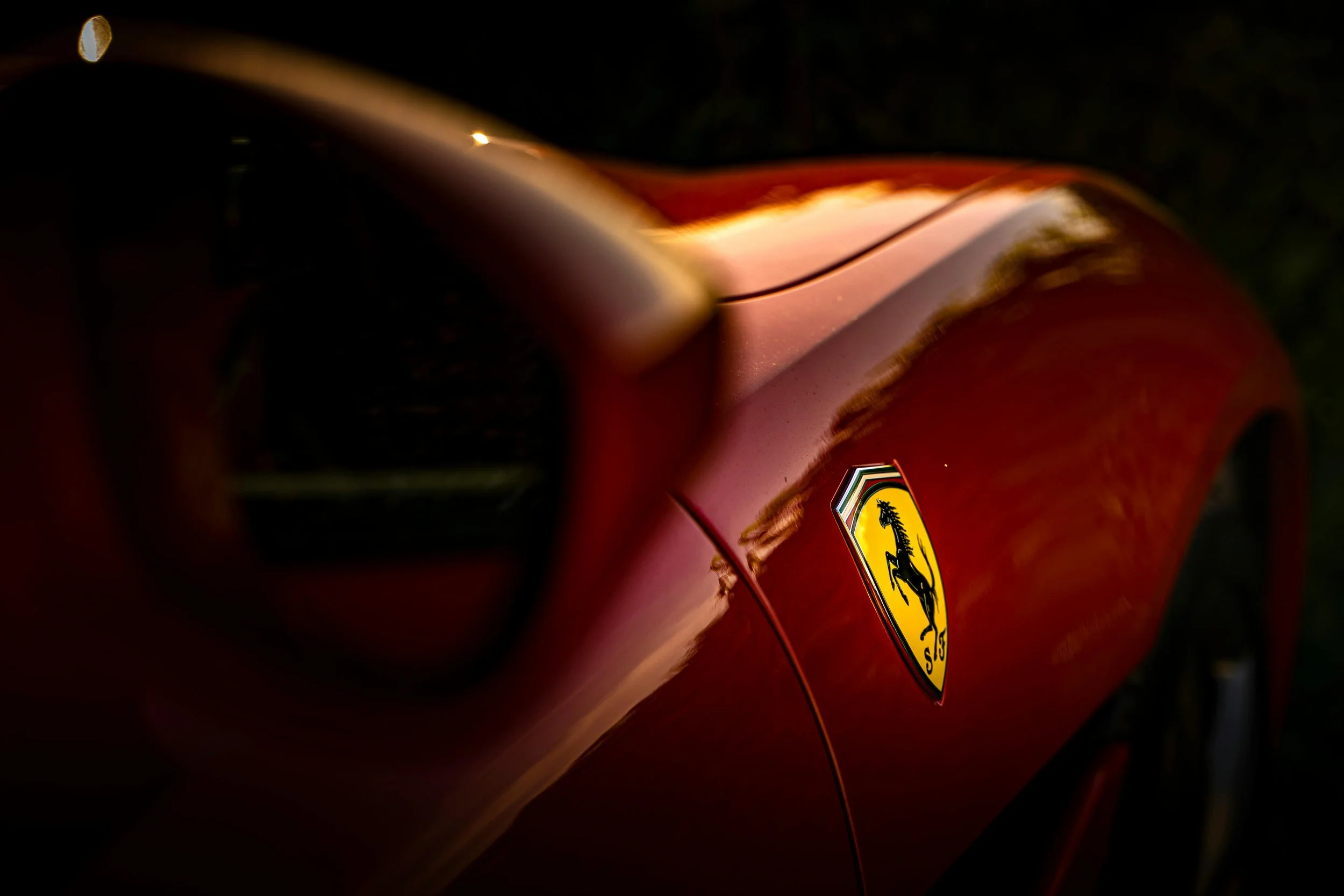 Ferrari-Logo auf rotem Sportwagenlack – das Cavallino Rampante als Symbol für Geschwindigkeit und Leidenschaft