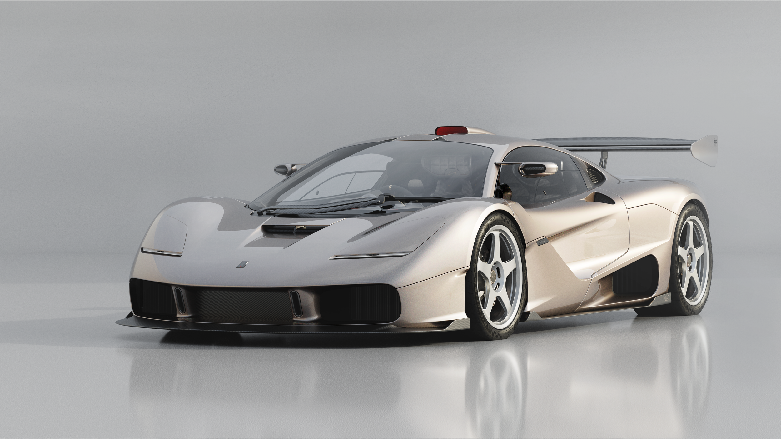 Gordon Murray Special Vehicles S1 LM in silver, front three-quarter view with large rear wing and Le Mans-inspired design.