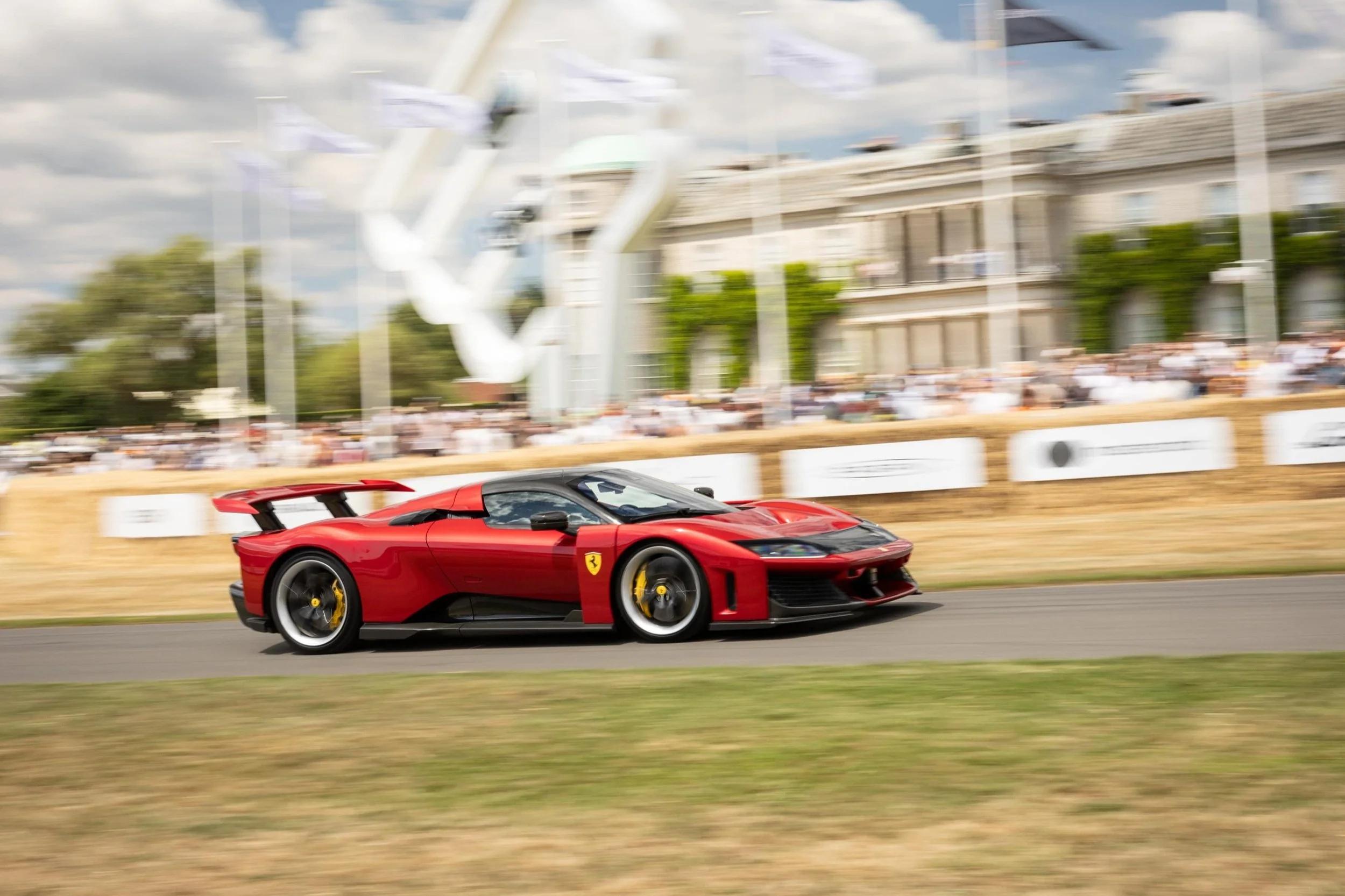 Ferrari F80 beim weltweiten dynamischen Debüt auf dem Goodwood Festival of Speed 2025 – das 1200 PS starke Hybrid-Supercar in Aktion vor der historischen Kulisse des Goodwood House.