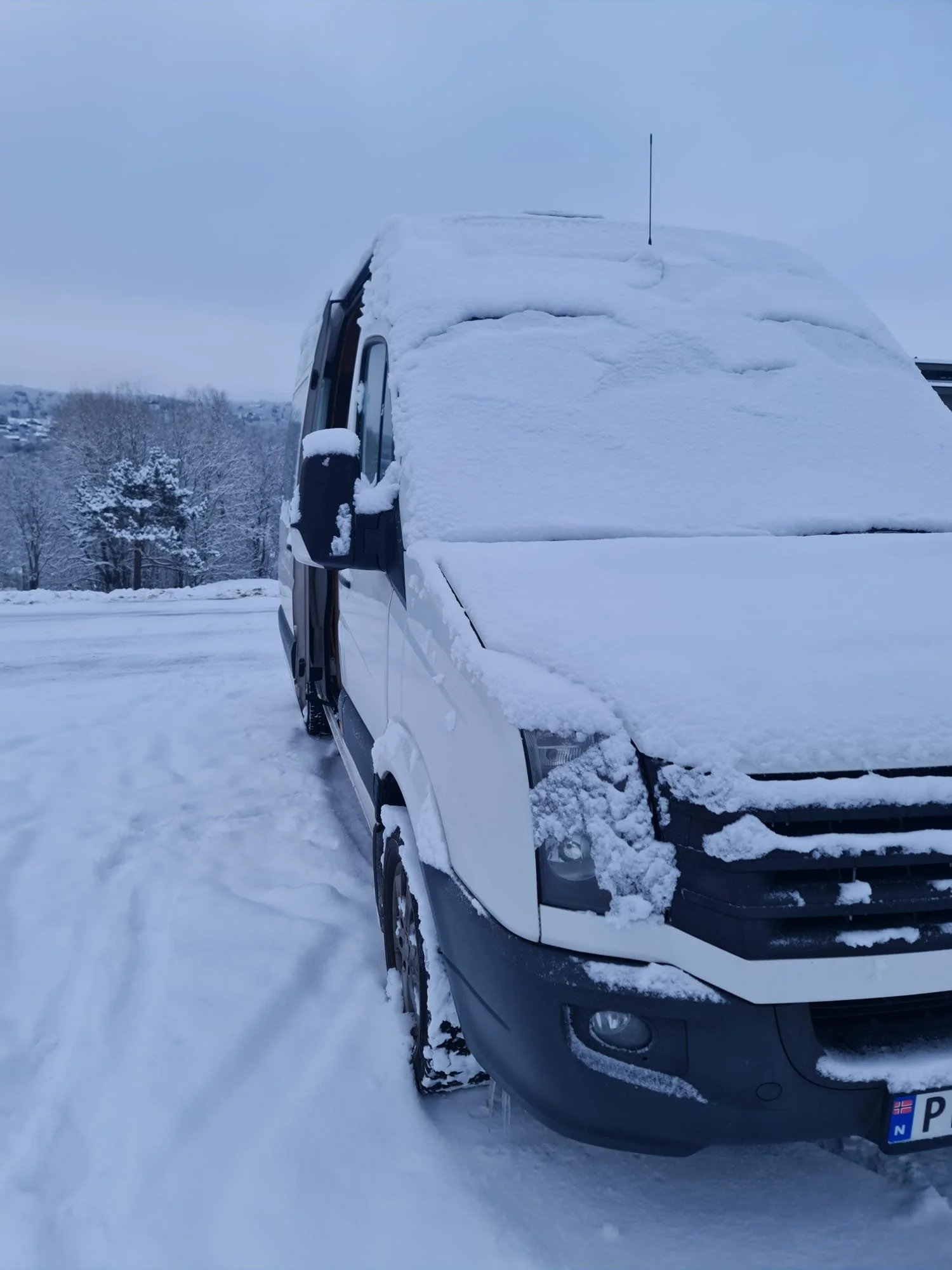Van covered in snow parked outdoors