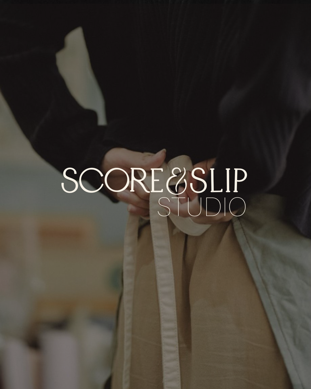 Person adjusting a white apron while wearing a black shirt.