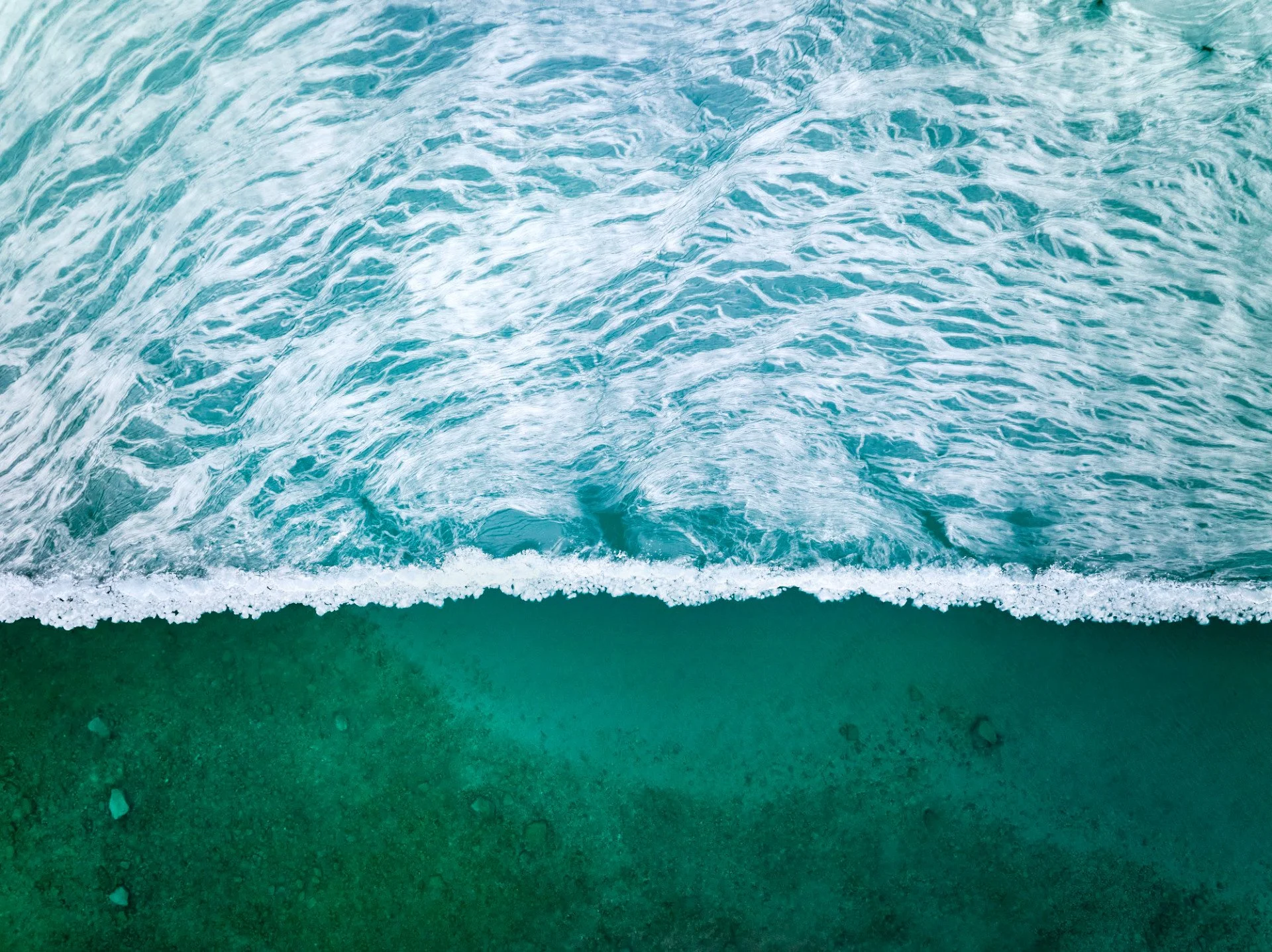 Crystalline ice patterns and emerald green open water taken over Lake Michigan with a drone near Charlevoix, Michigan by James Manning in a piece titled "Lake Stasis"