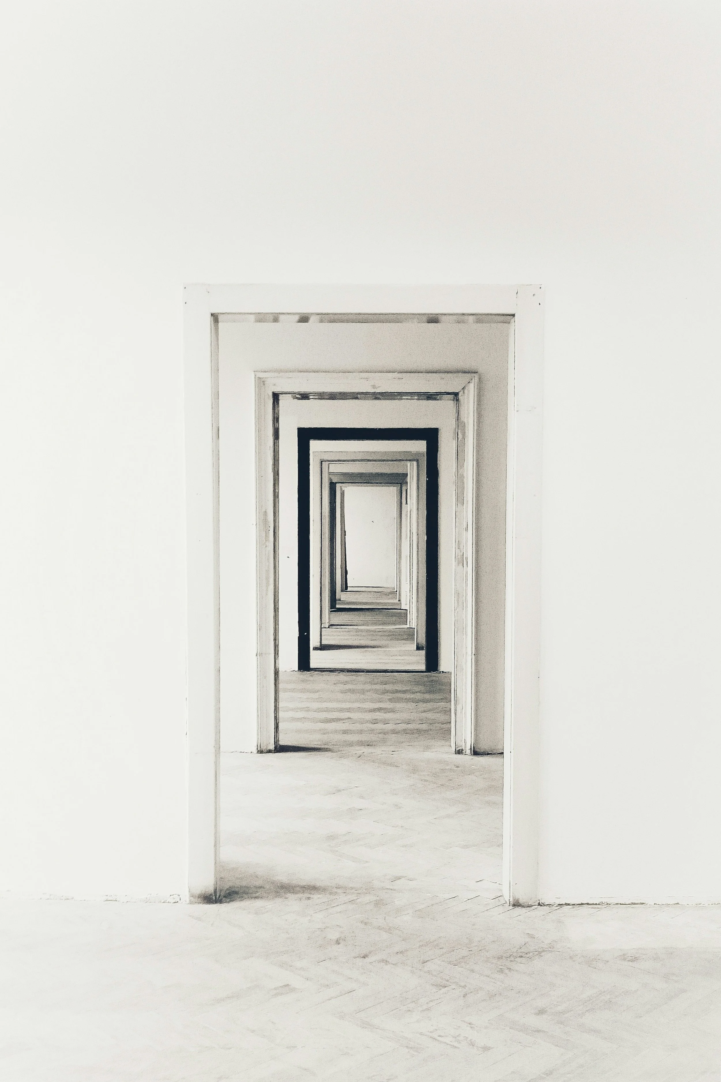 A series of open doorways visible in a hallway, creating a repetitive, infinite effect, with a soft, monochromatic color scheme.